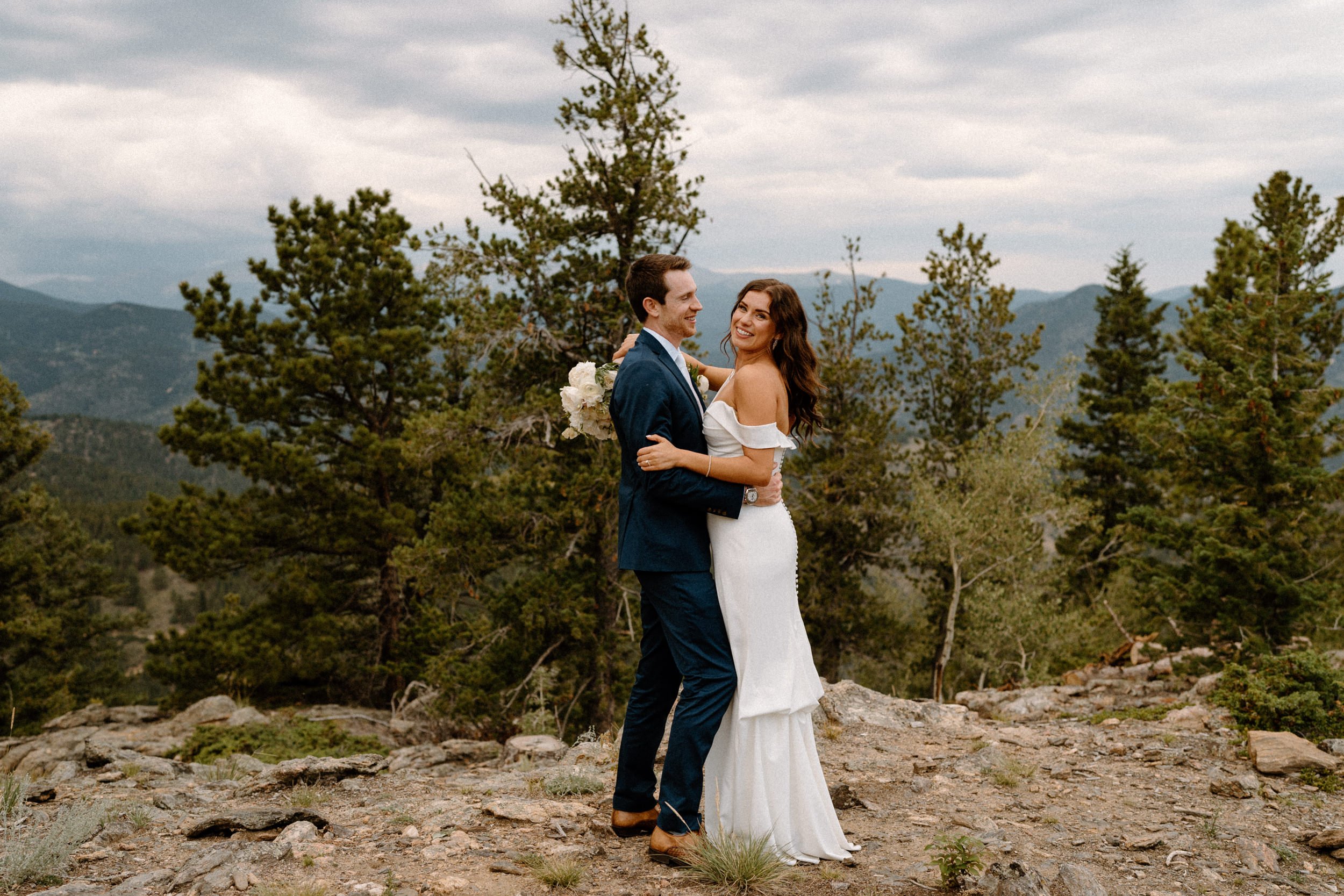 The bride and groom embrace and smile outside of North Star Gatherings in Idaho Springs, CO