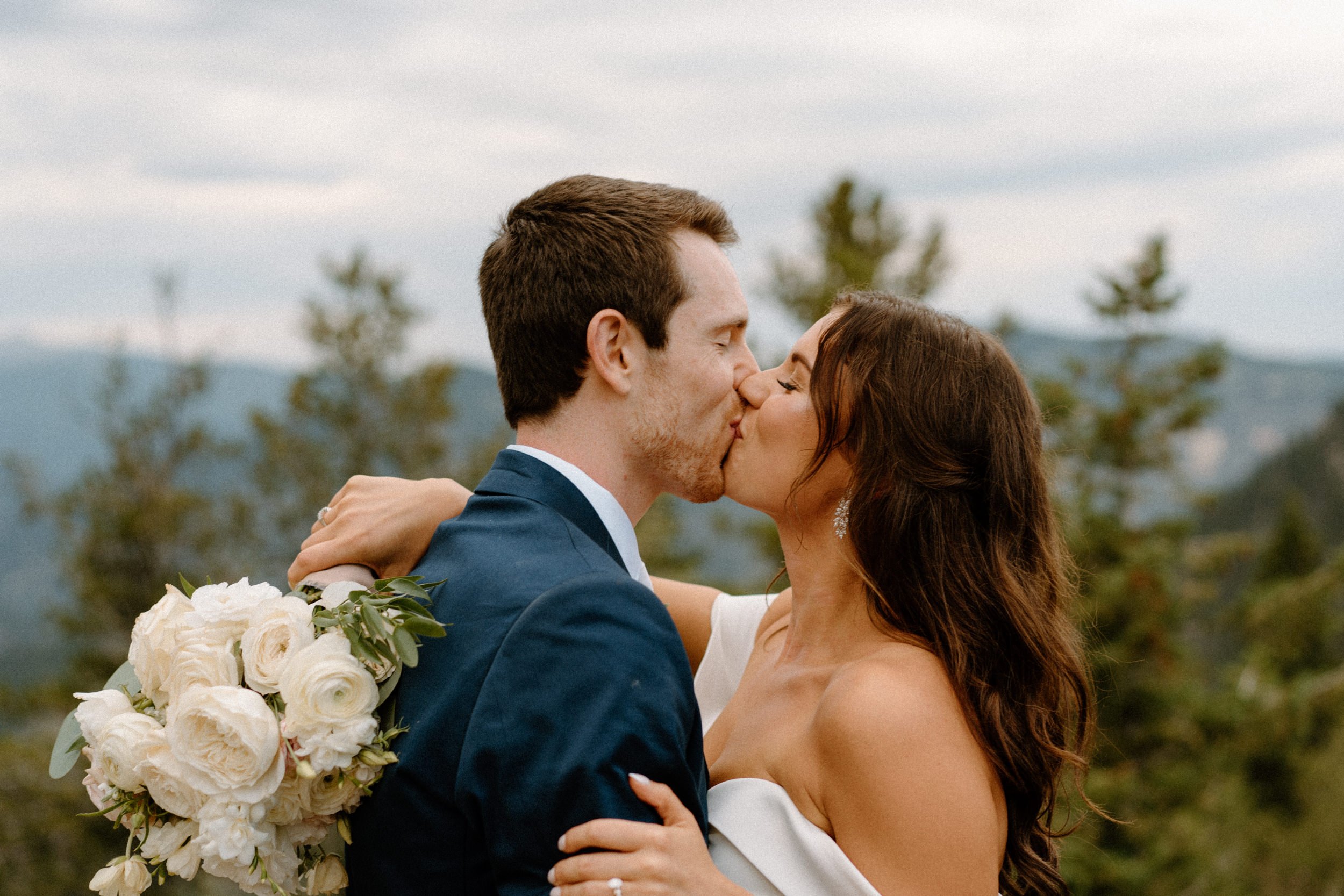 The bride and groom kiss outside of North Star Gatherings in Idaho Springs, CO