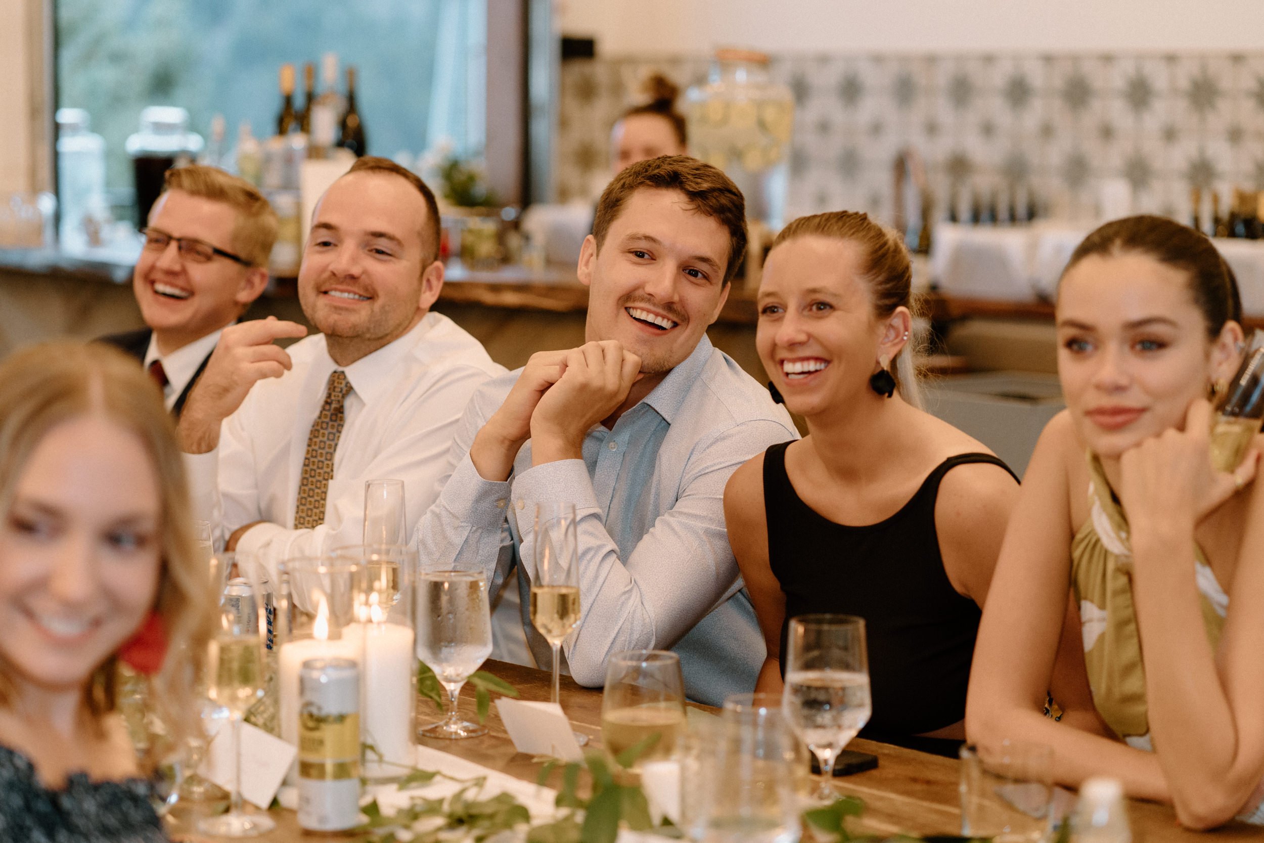 Wedding guests laugh during the toasts