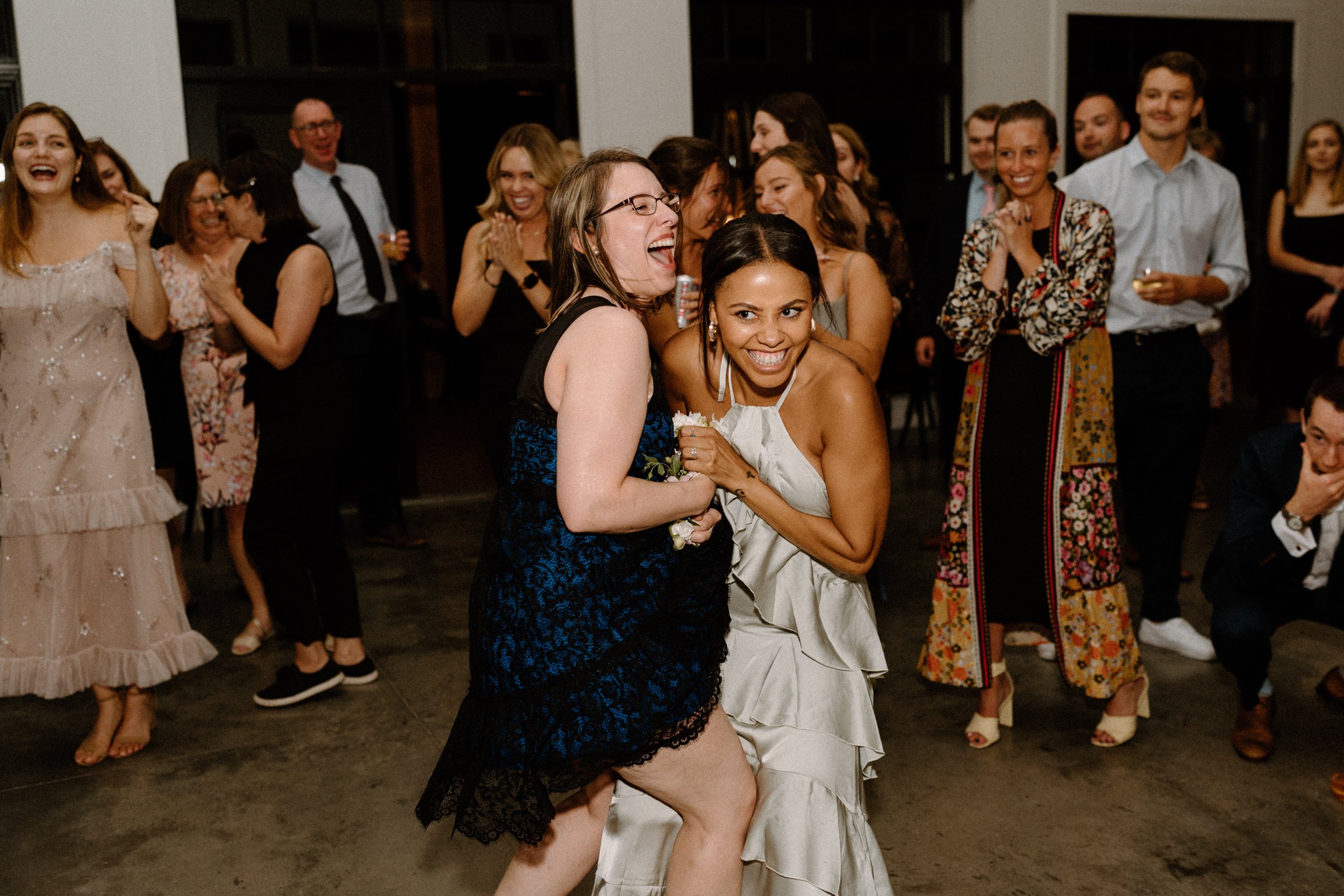 Wedding guests dance together on the dance floor