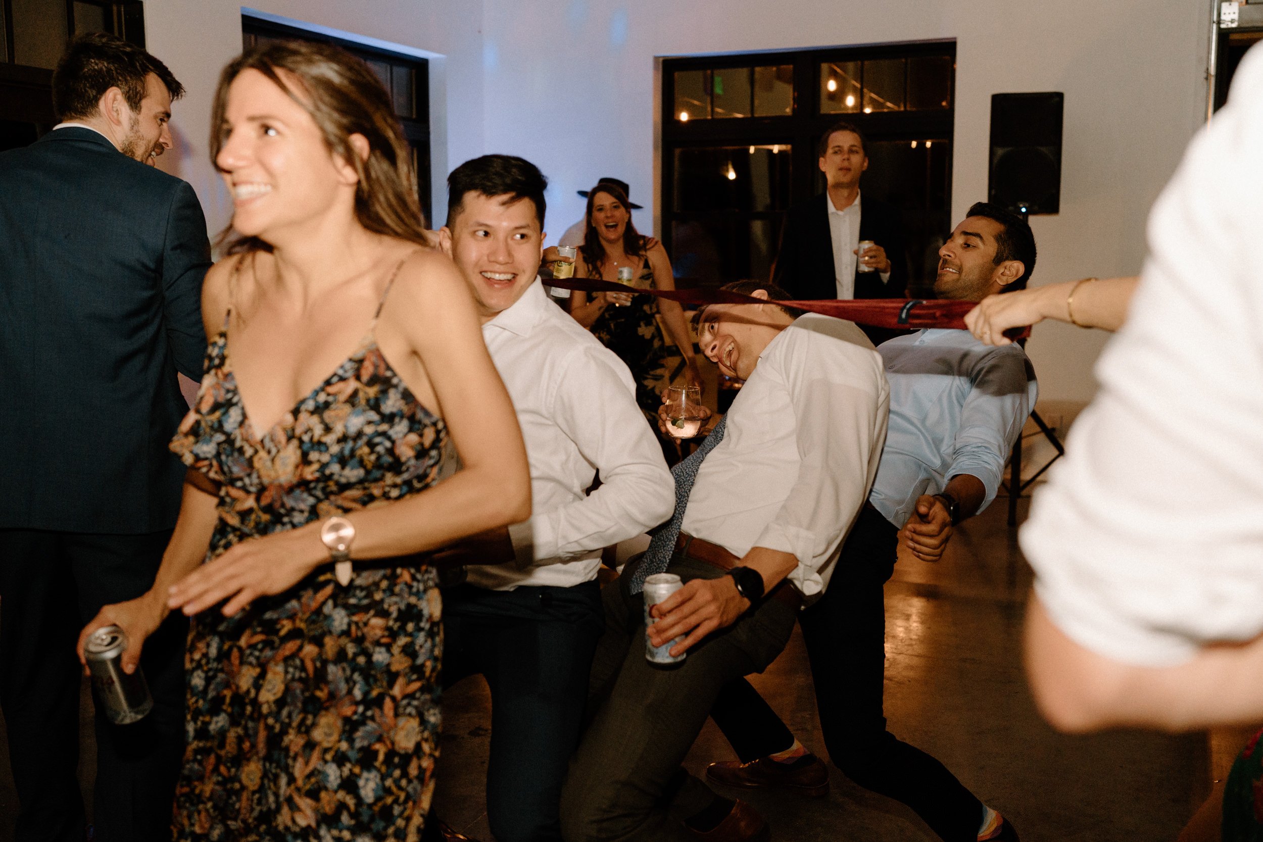 Wedding guests do the limbo on the dance floor