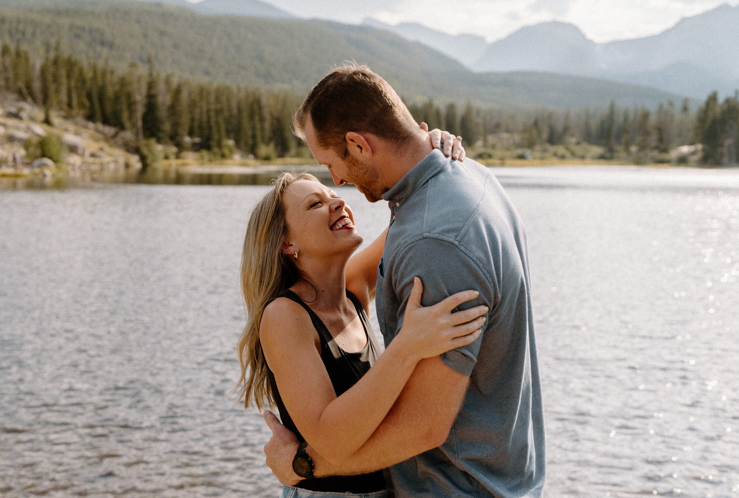 Man and woman laugh at each other during engagement session