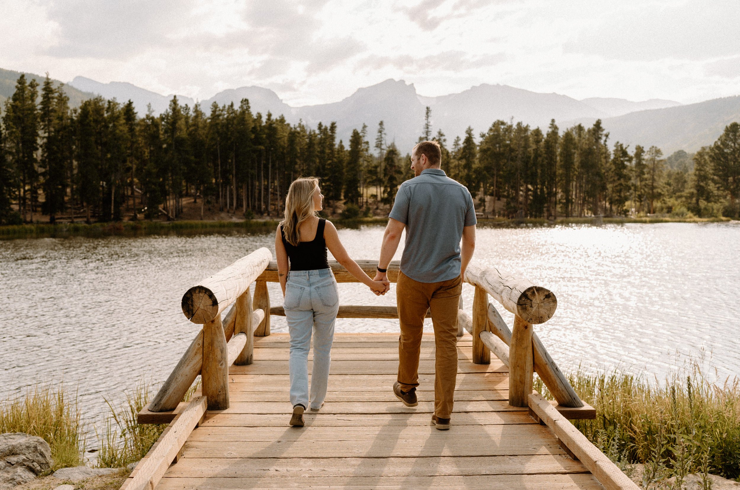 Man and woman walk onto scenic overlook at Sprague Lake at Rocky Mountain National Park