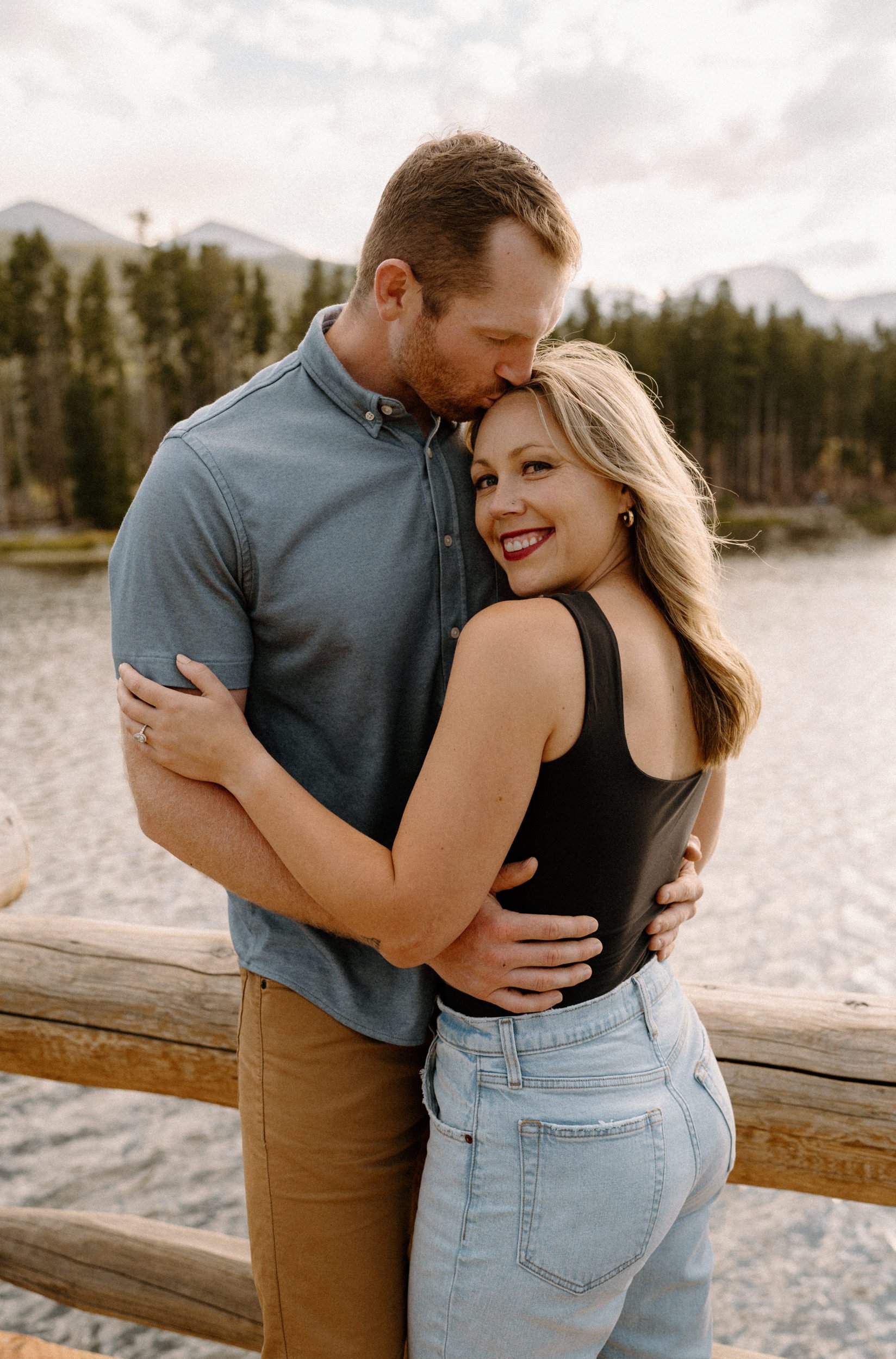 Man kisses woman on the head at Sprague Lake at Rocky Mountain National Park