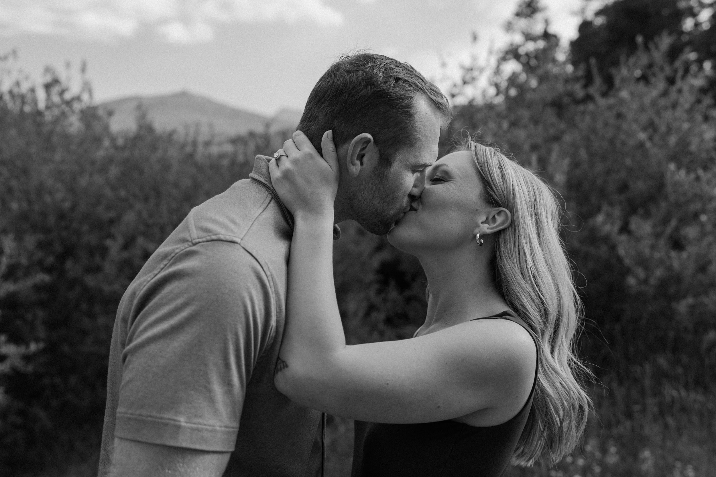 Man and woman kiss during Rocky Mountain National Park engagement session