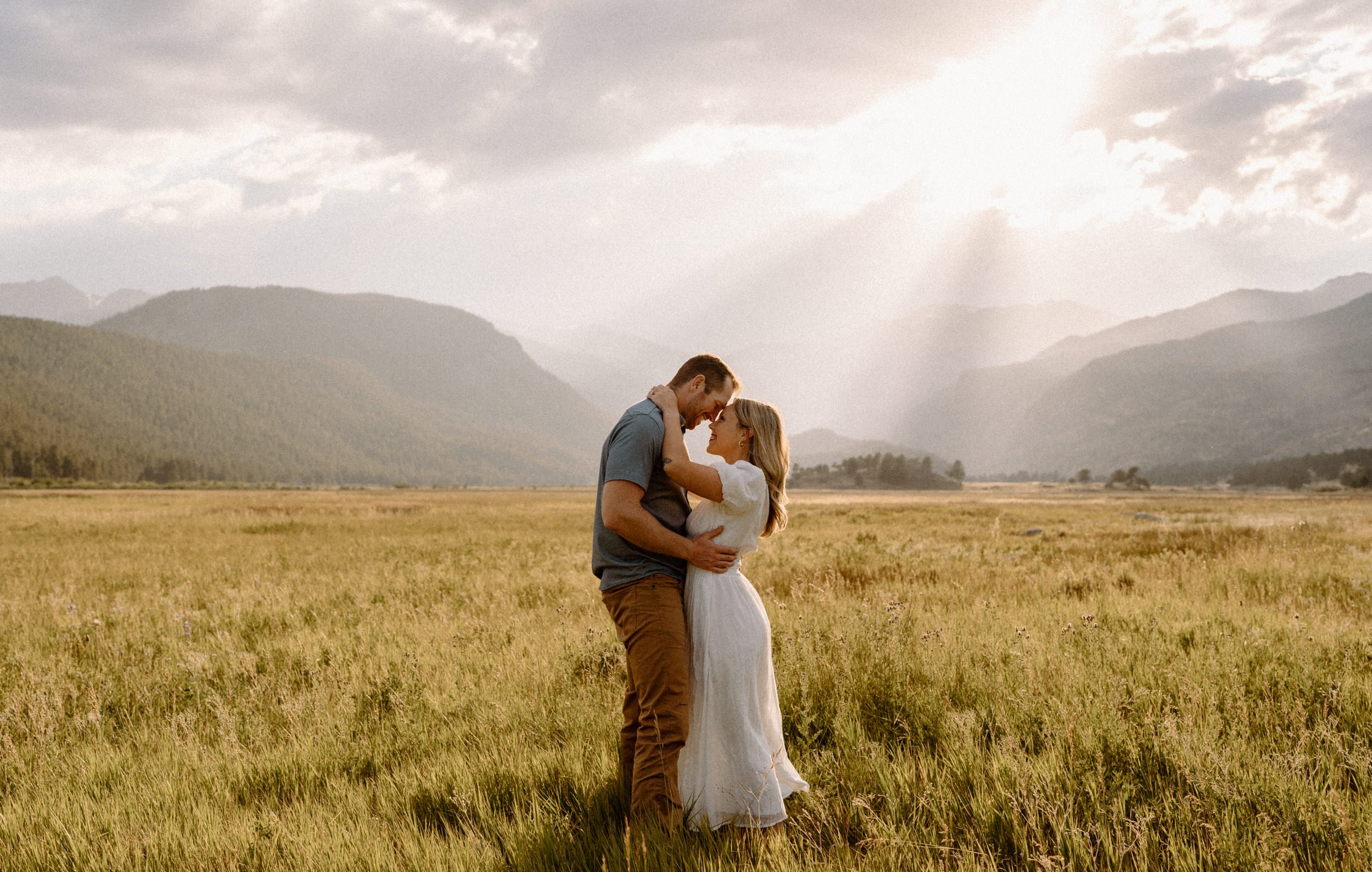 Man and woman embrace in a meadow in Rocky Mountain National Park