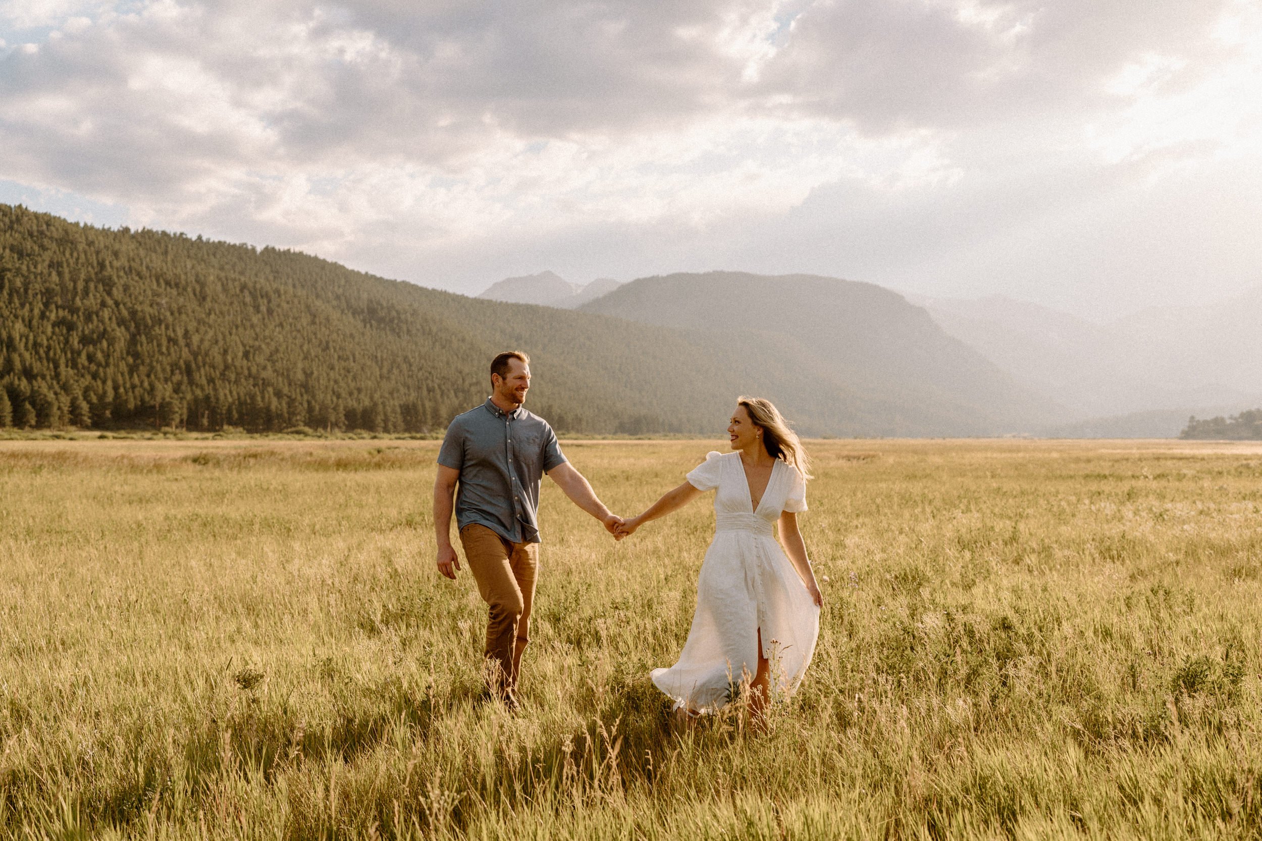 Woman leads man through a meadow in Rocky Mountain National Park