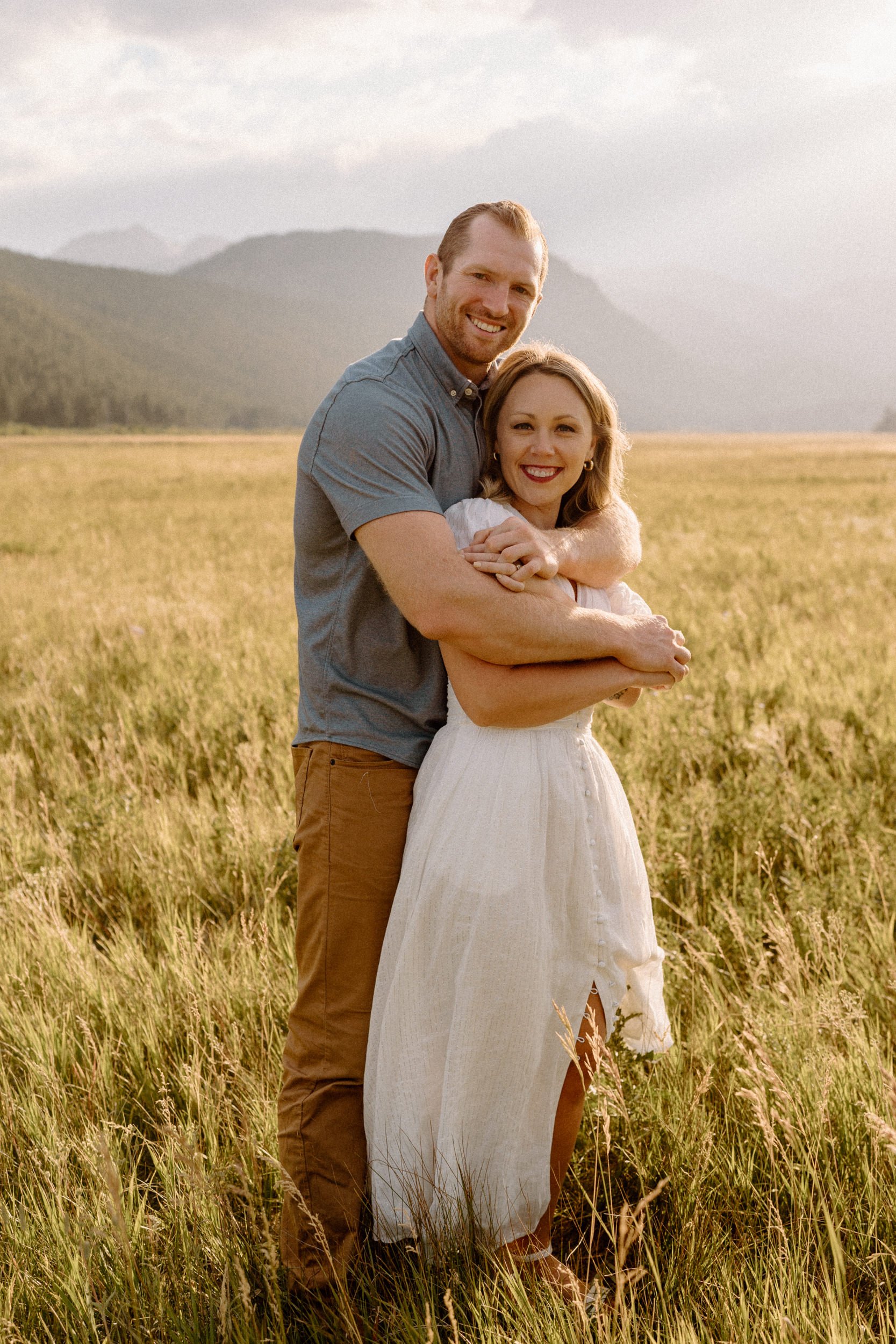 Man and woman embrace in a meadow in Rocky Mountain National Park