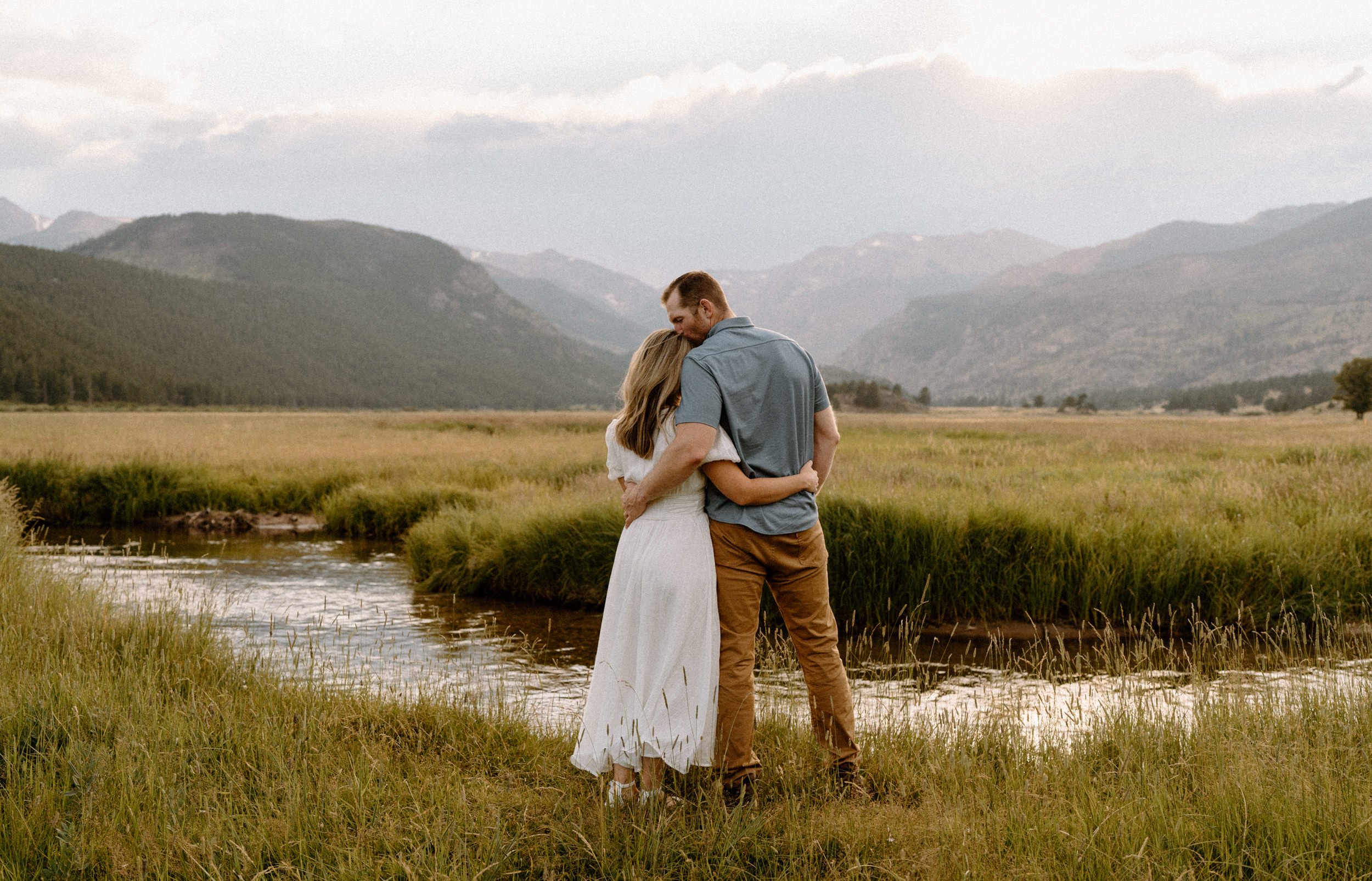 Man and woman overlook a meadow creek in Rocky Mountain National Park
