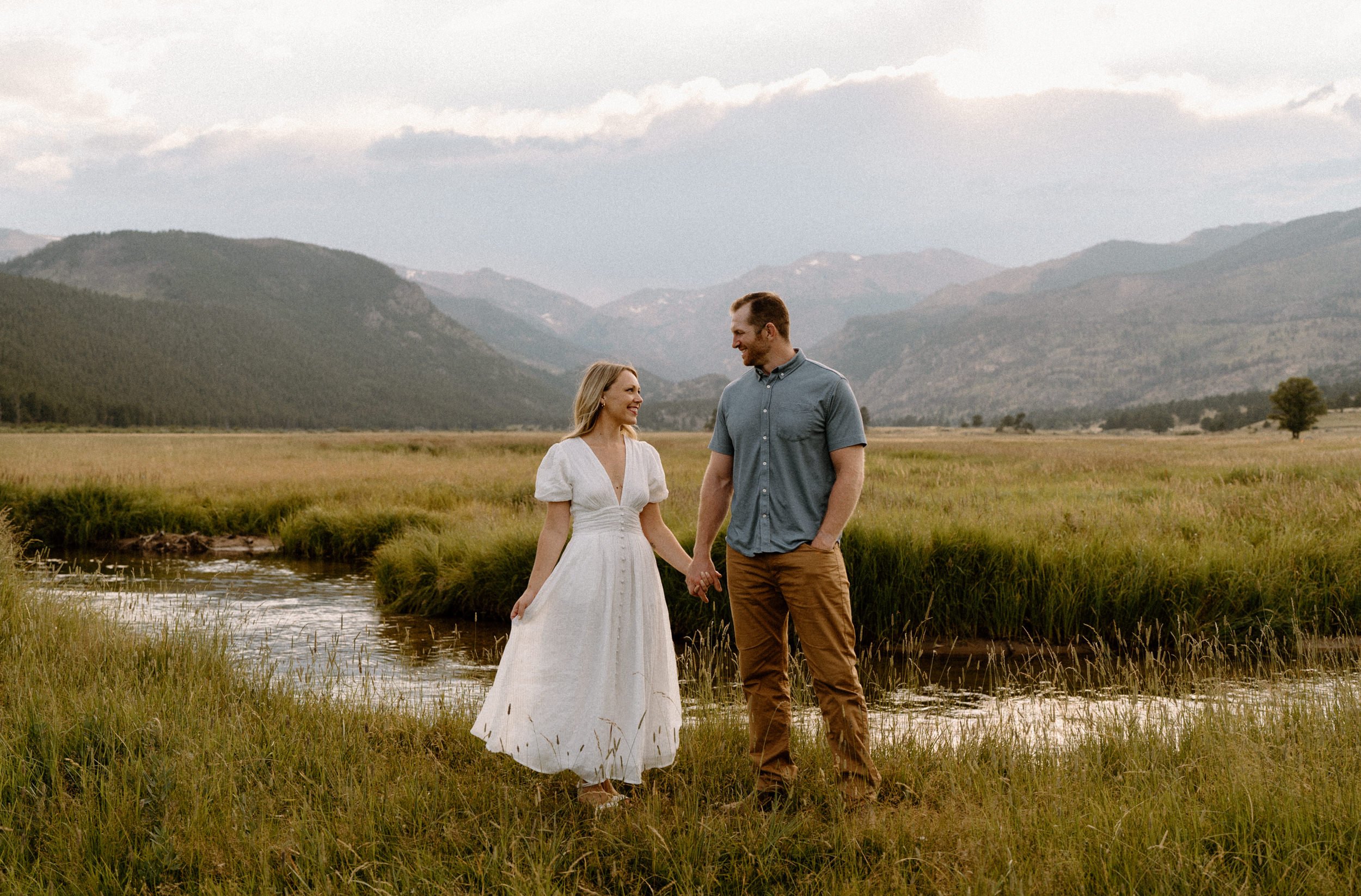 Man and woman pose in front of meadow creek in Rocky Mountain National Park