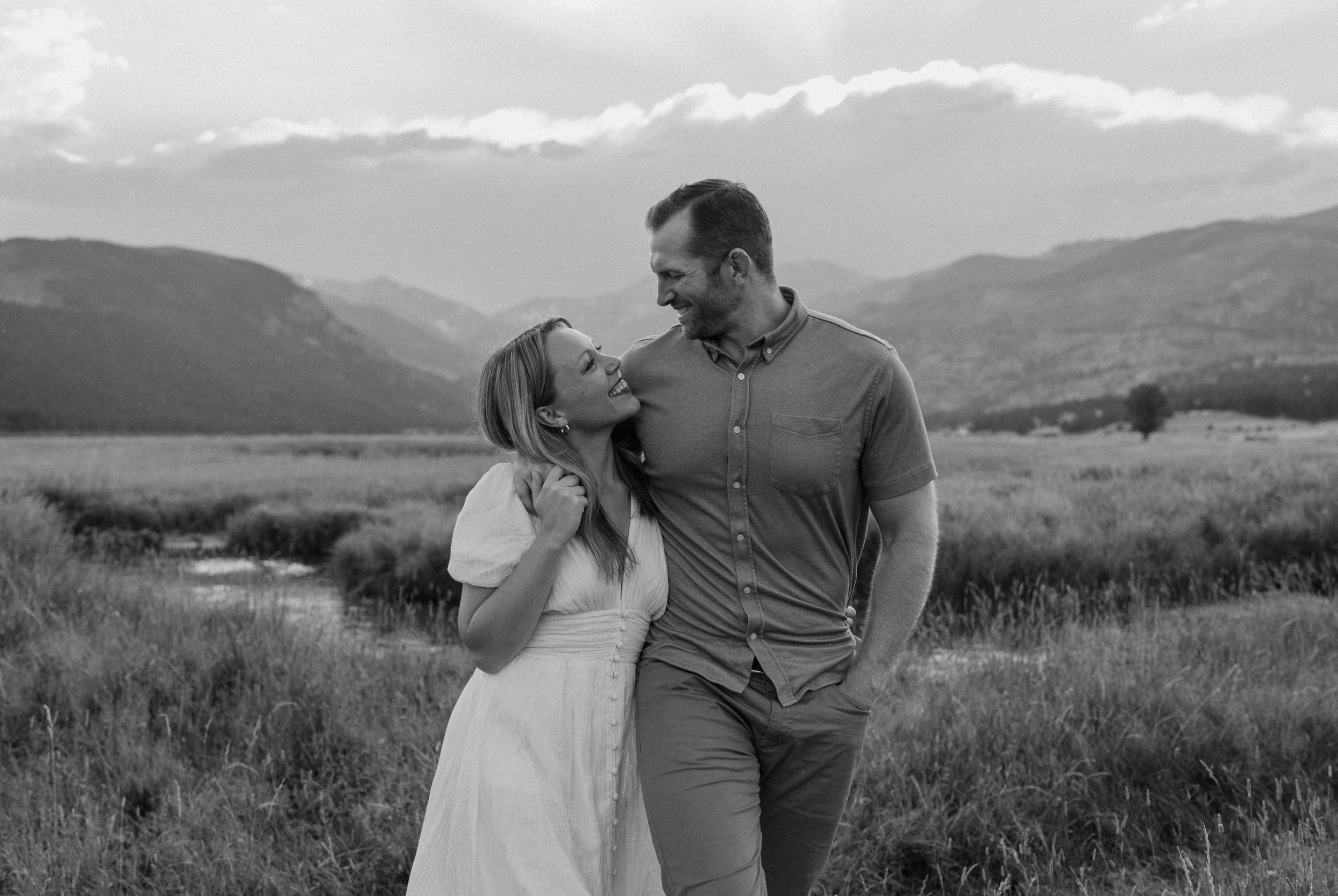 Man and woman smile at each other during engagement session in Rocky Mountain National Park