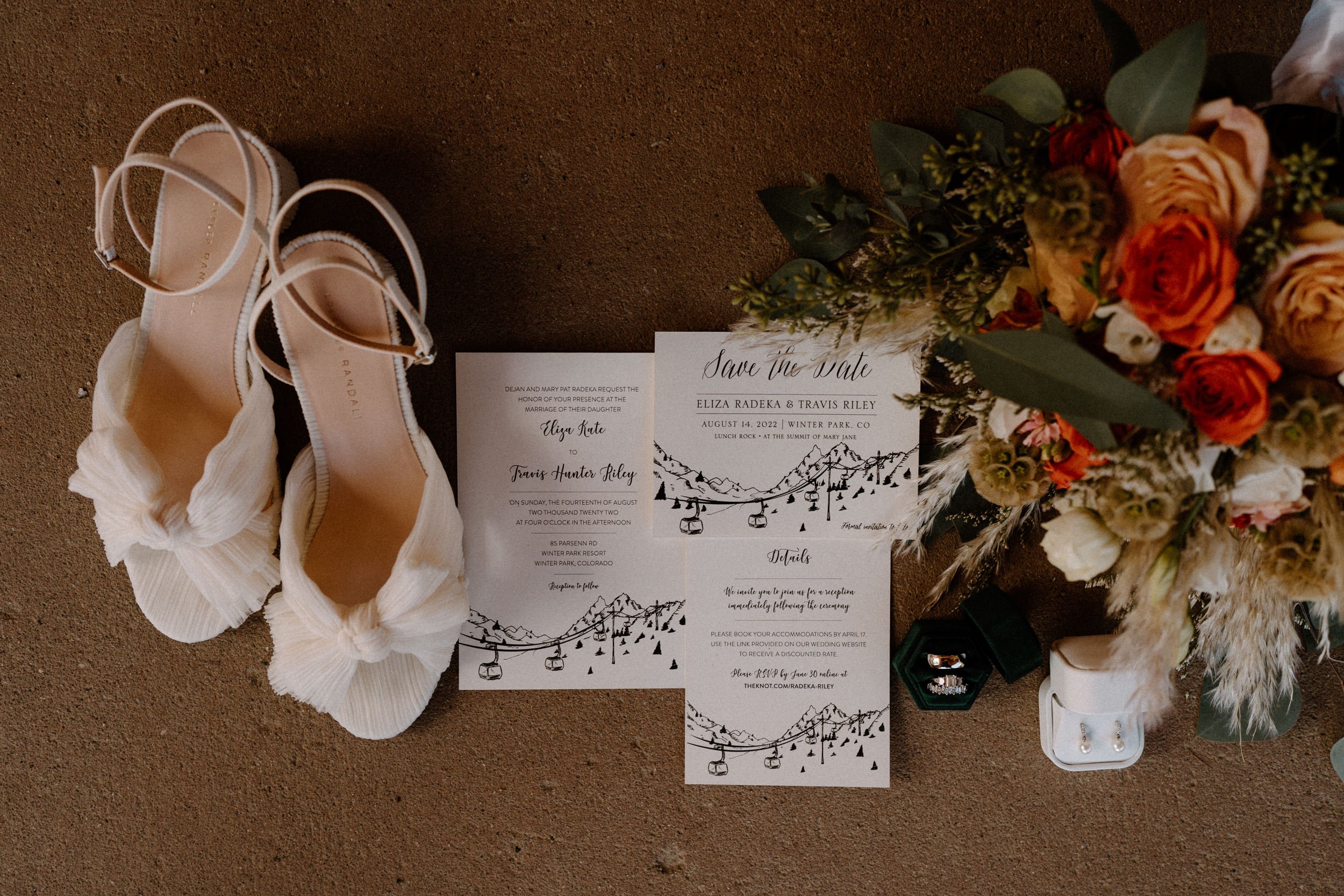 Close up of the bride's heels, bouquet, ring, and save the date