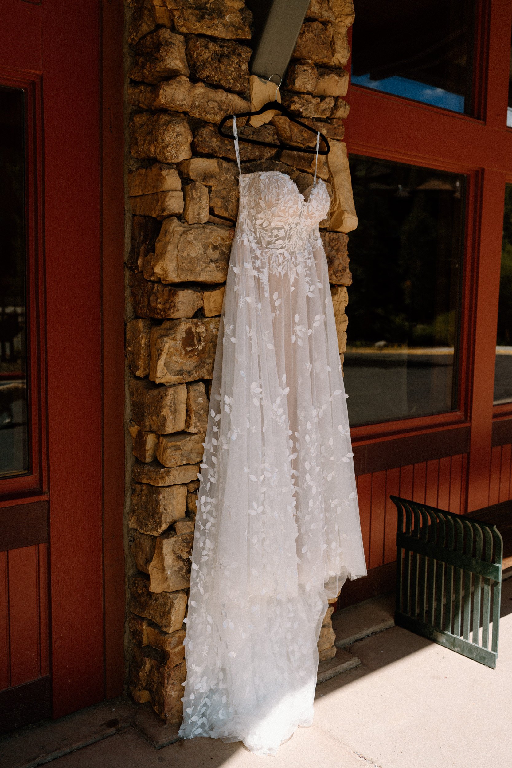 A white wedding dress hangs from a cabin frame
