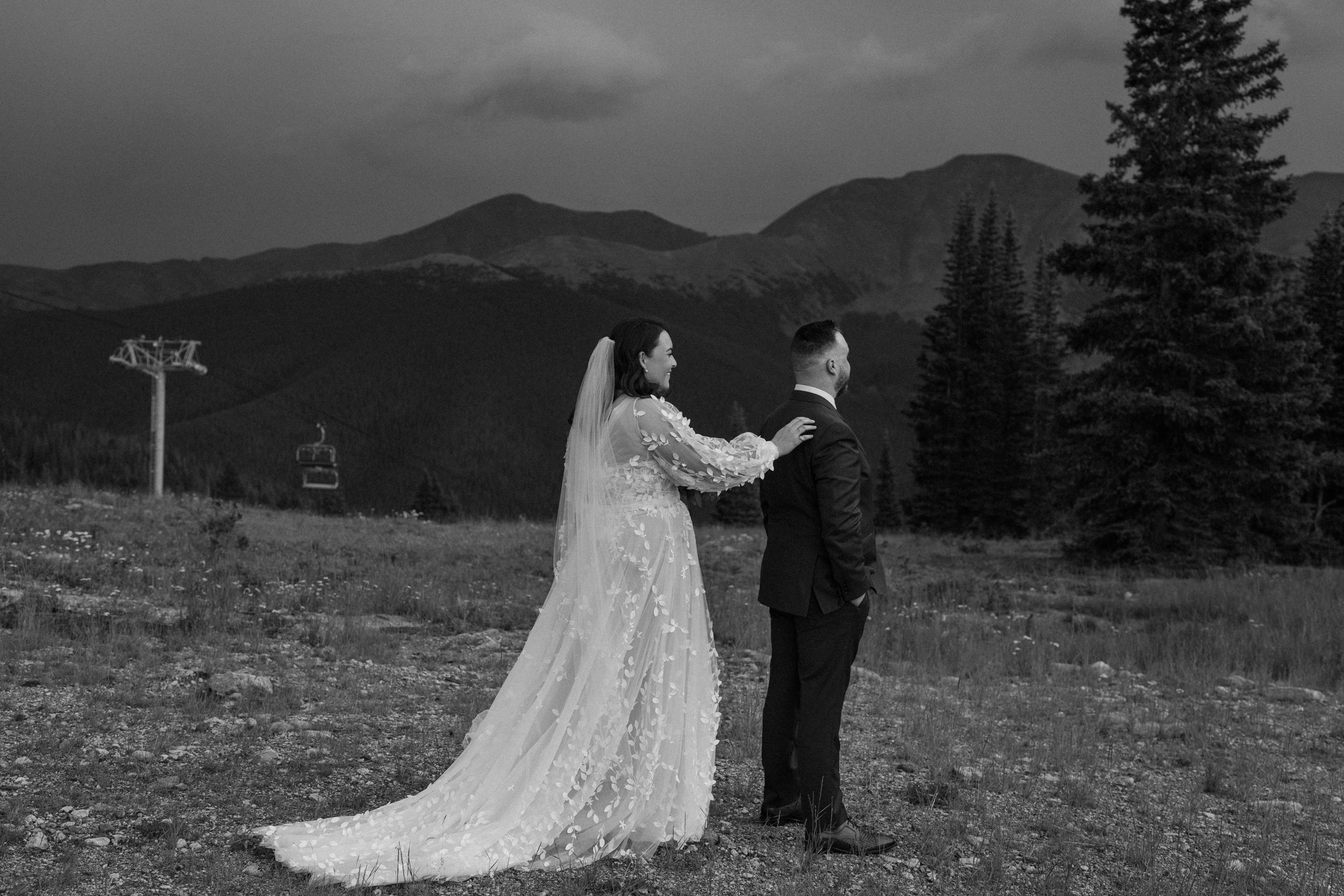 The bride touches the groom's shoulder during their first look