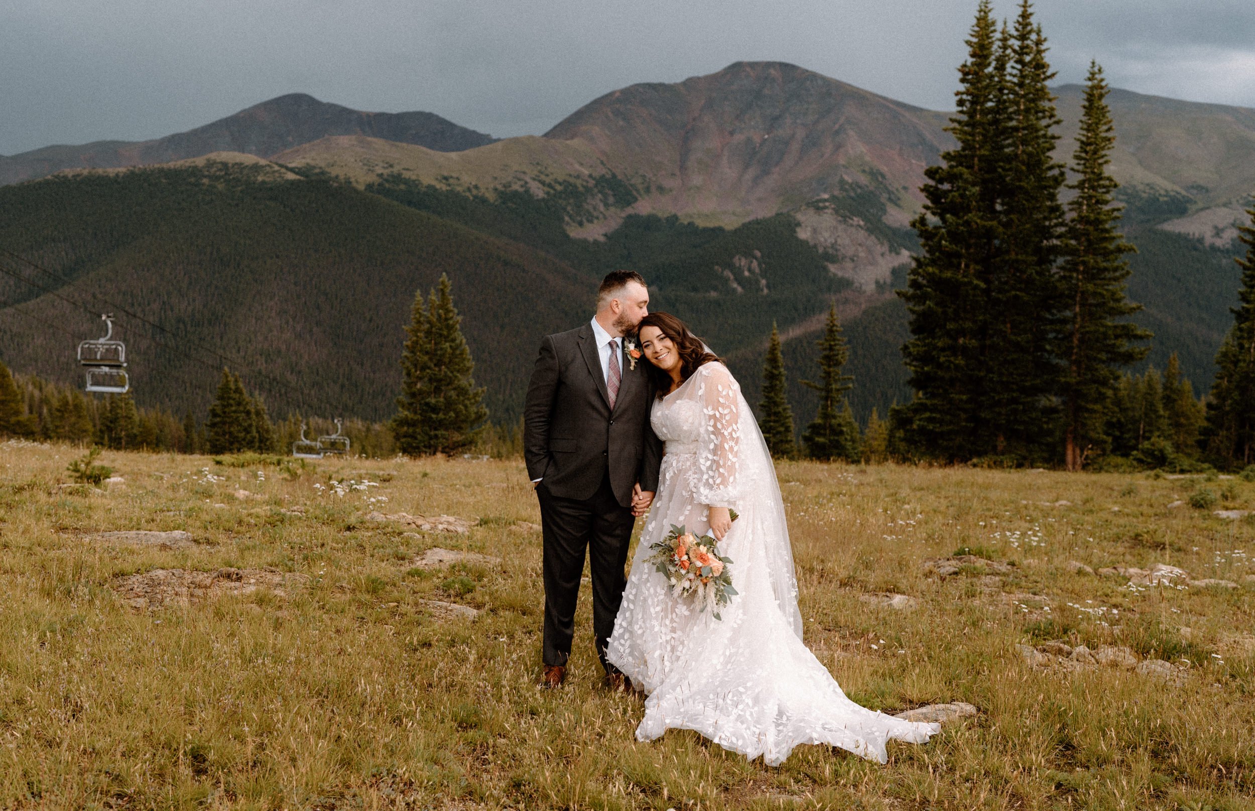 Bride and groom pose on the mountain at Lunch Rock in Winter Park, CO