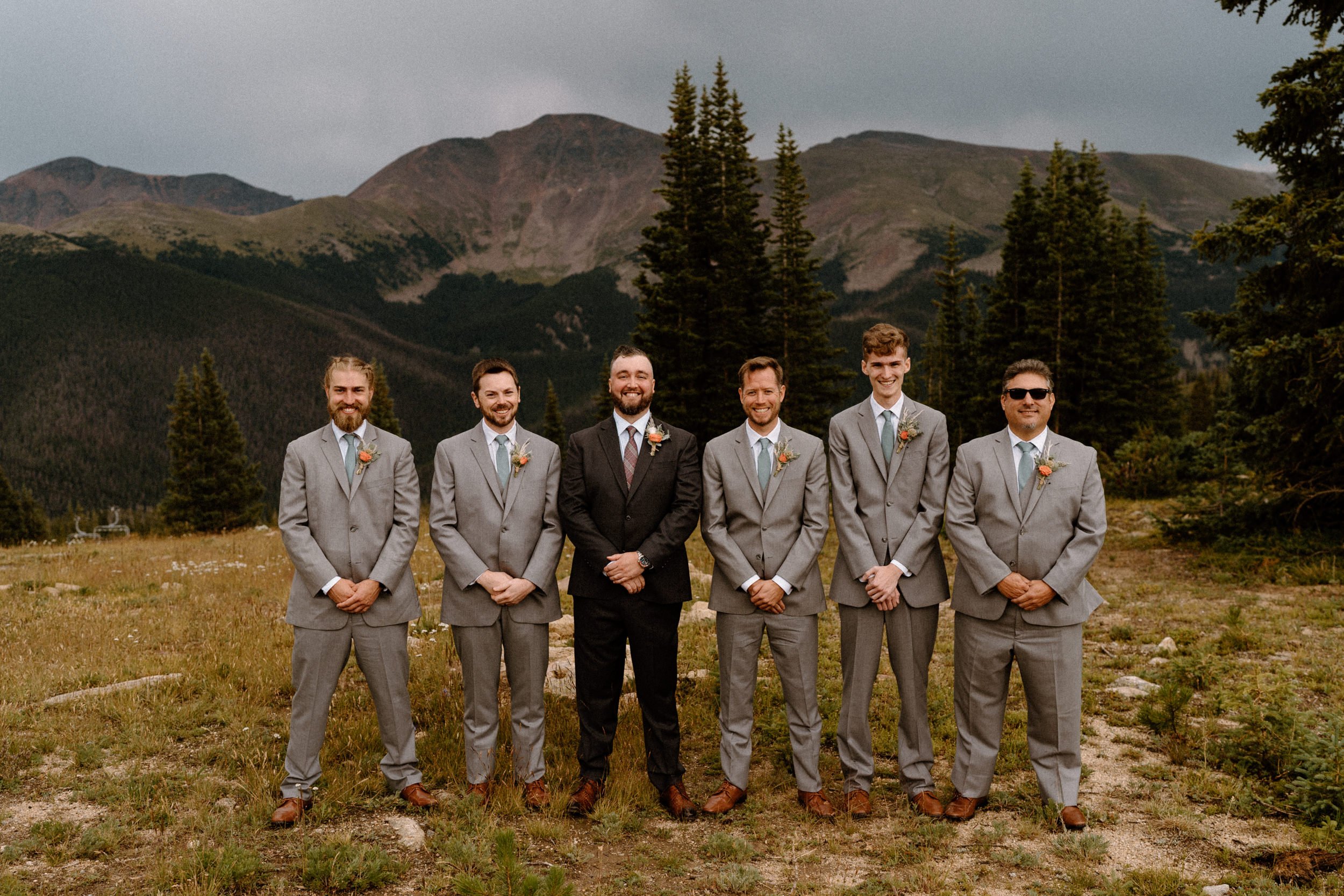 Groom poses with his groomsmen at the top of Lunch Rock in Winter Park, CO
