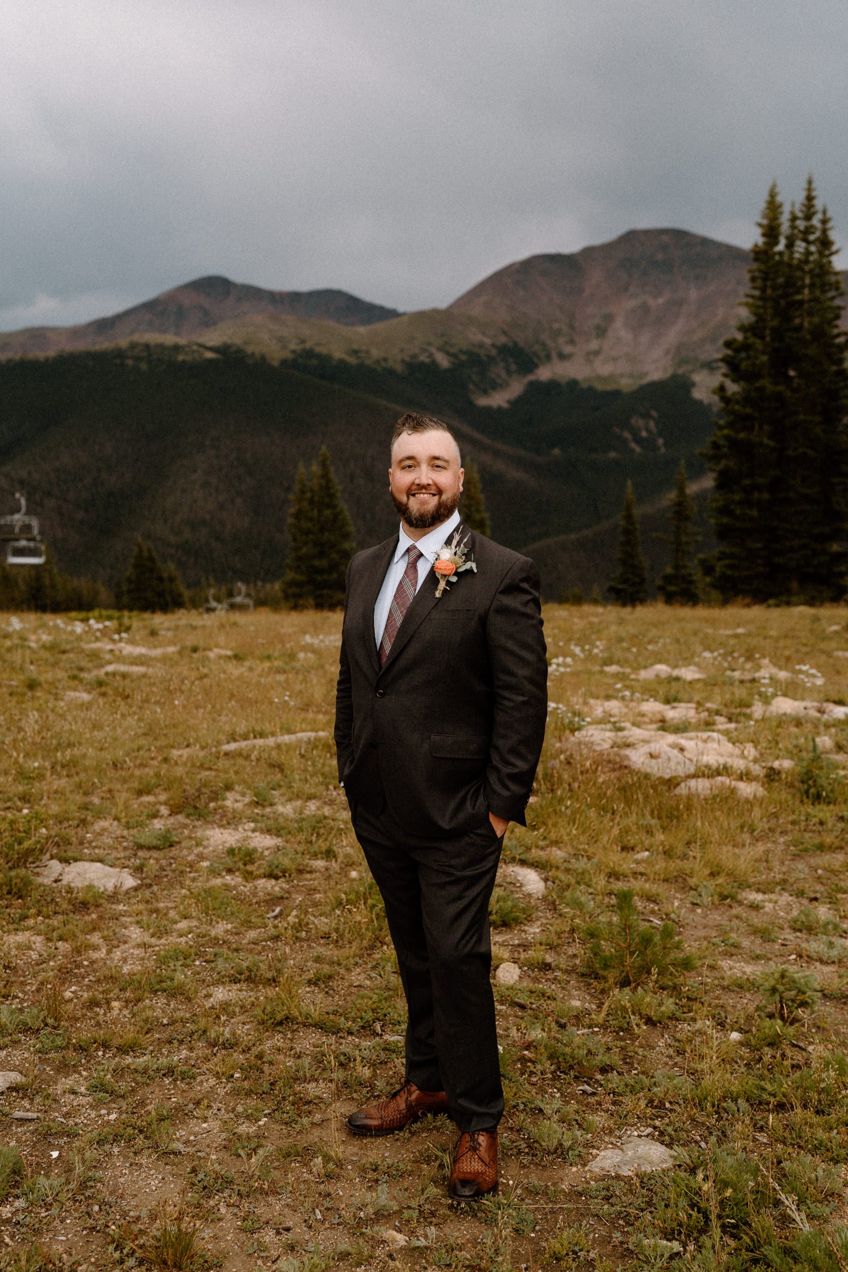 Groom poses on the top of Lunch Rock in Winter Park, CO