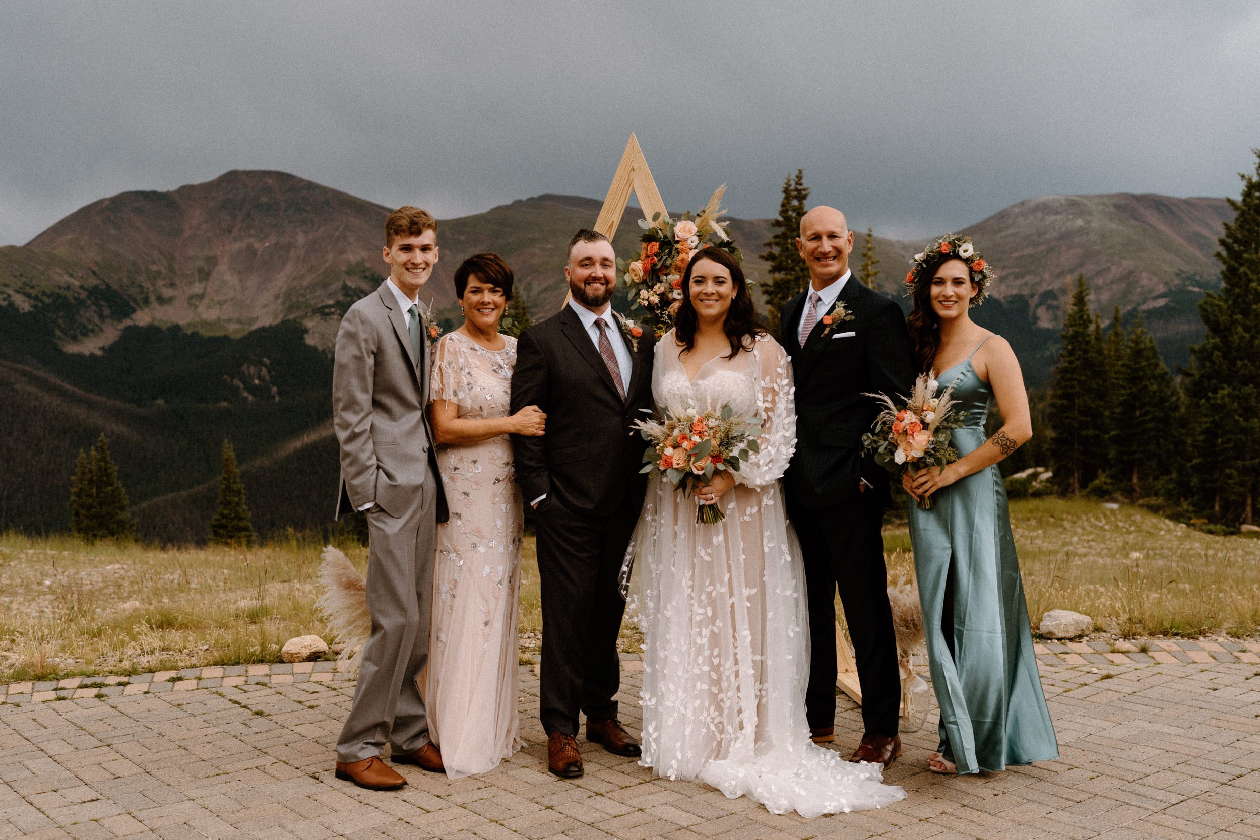 Bride and groom pose with their family at the top of Lunch Rock in Winter Park, CO