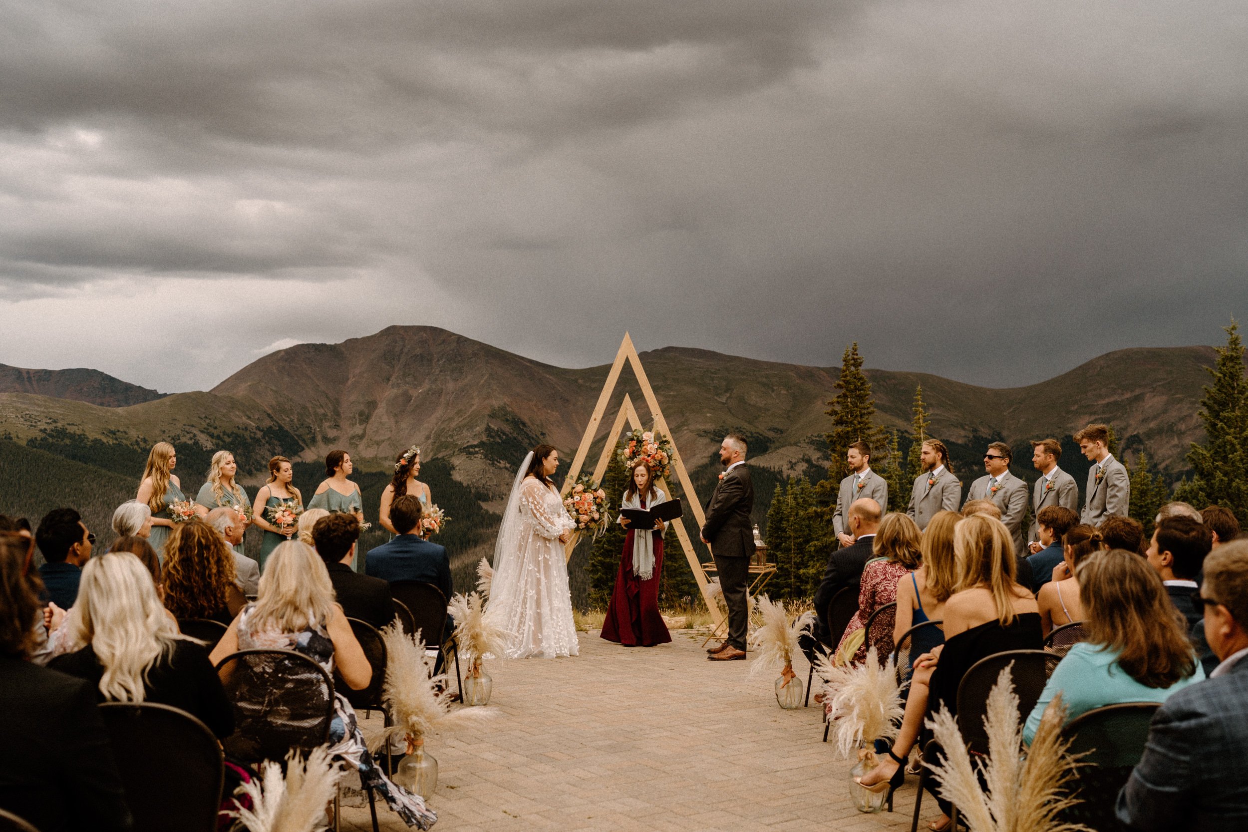 Bride and groom stand at the altar as guests watch at Lunch Rock in Winter Park, CO