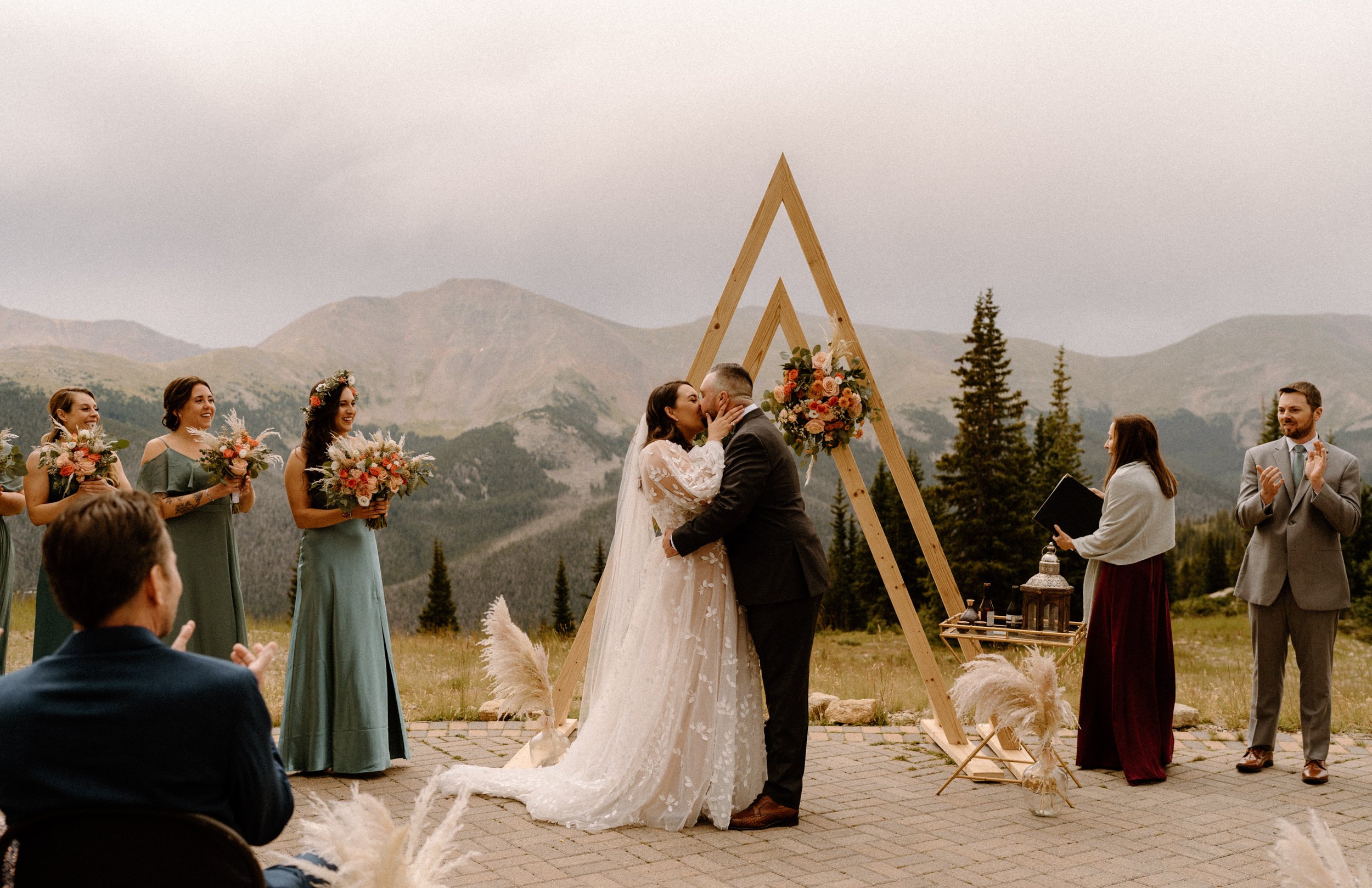 Bride and groom share their first kiss at the altar at Lunch Rock in Winter Park, CO