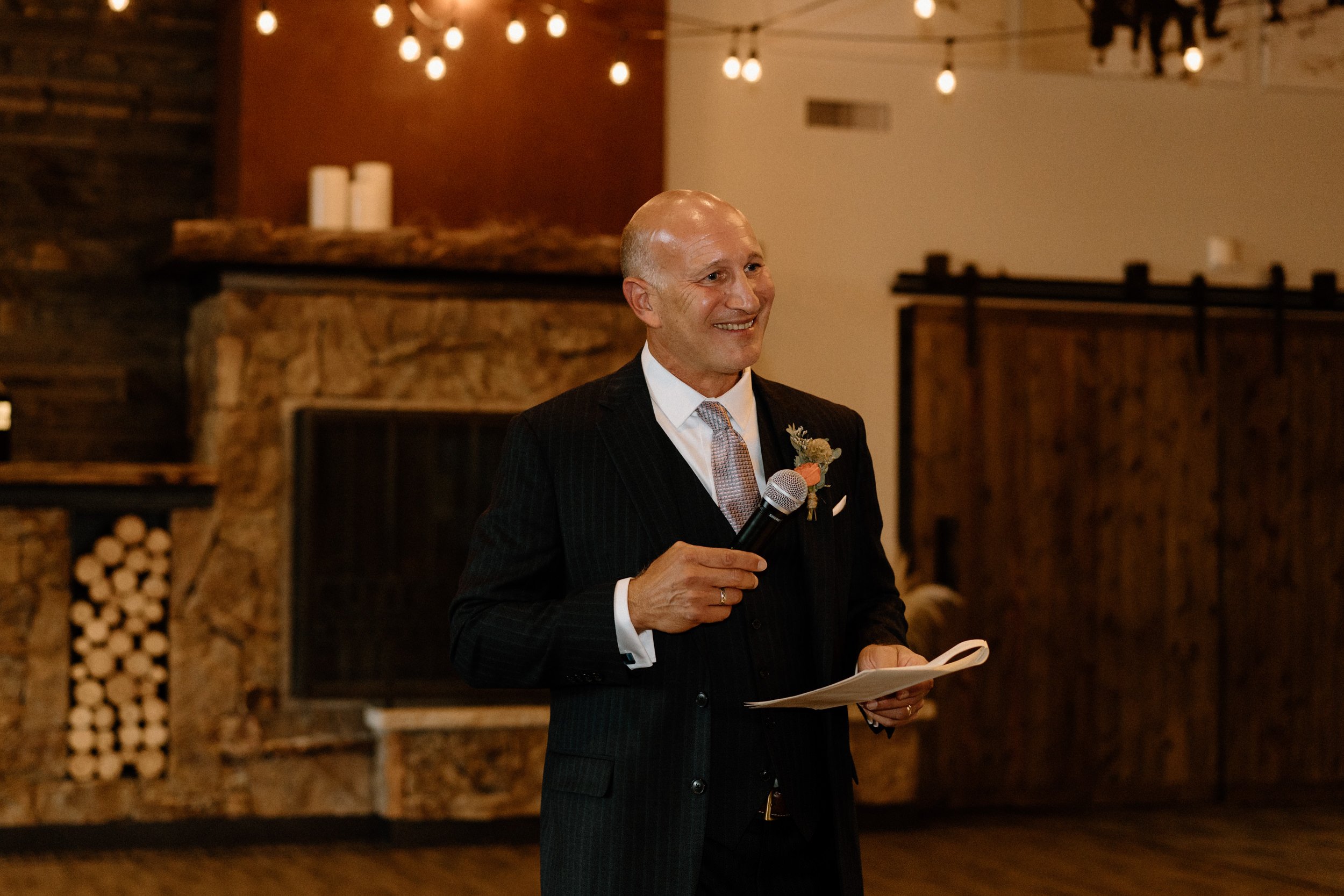 Father of the bride smiles while making a toast