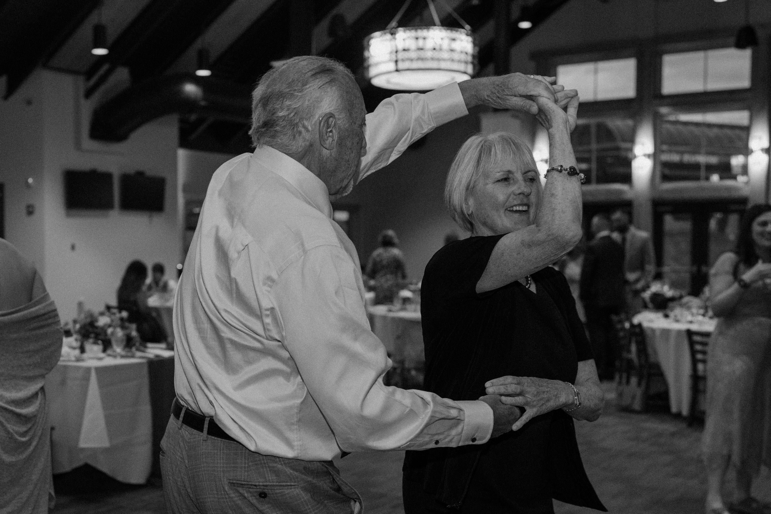 A man twirls a woman around during the reception dance