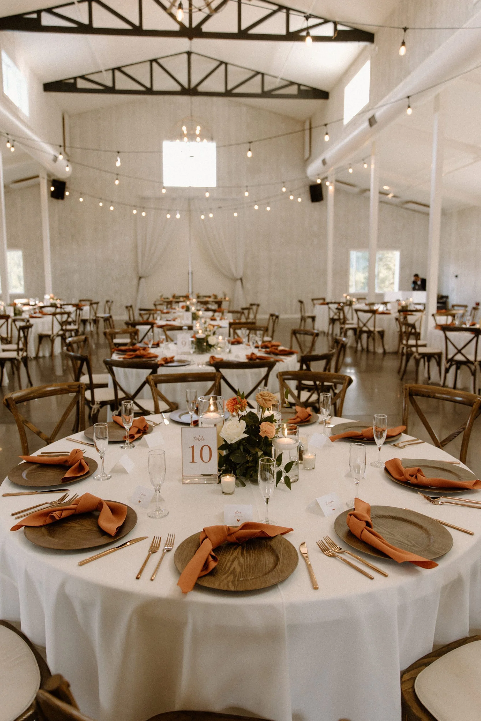Reception area decorated with orange and white flowers and napkins