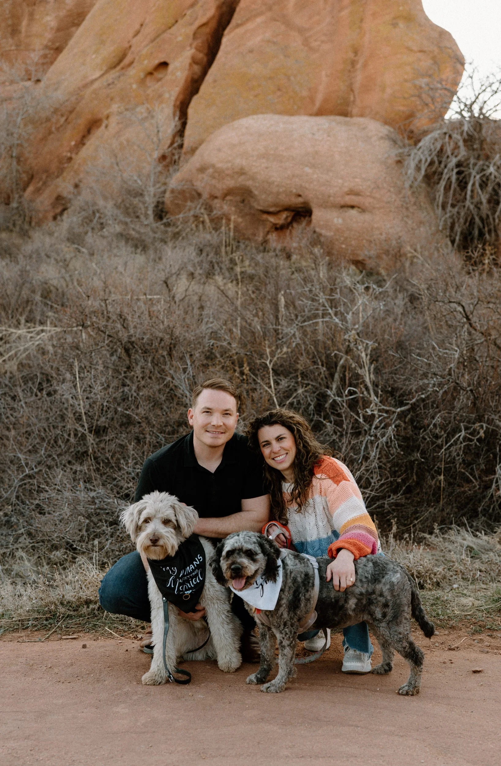 Couple smiling with their dogs at engagement session in Red Rocks