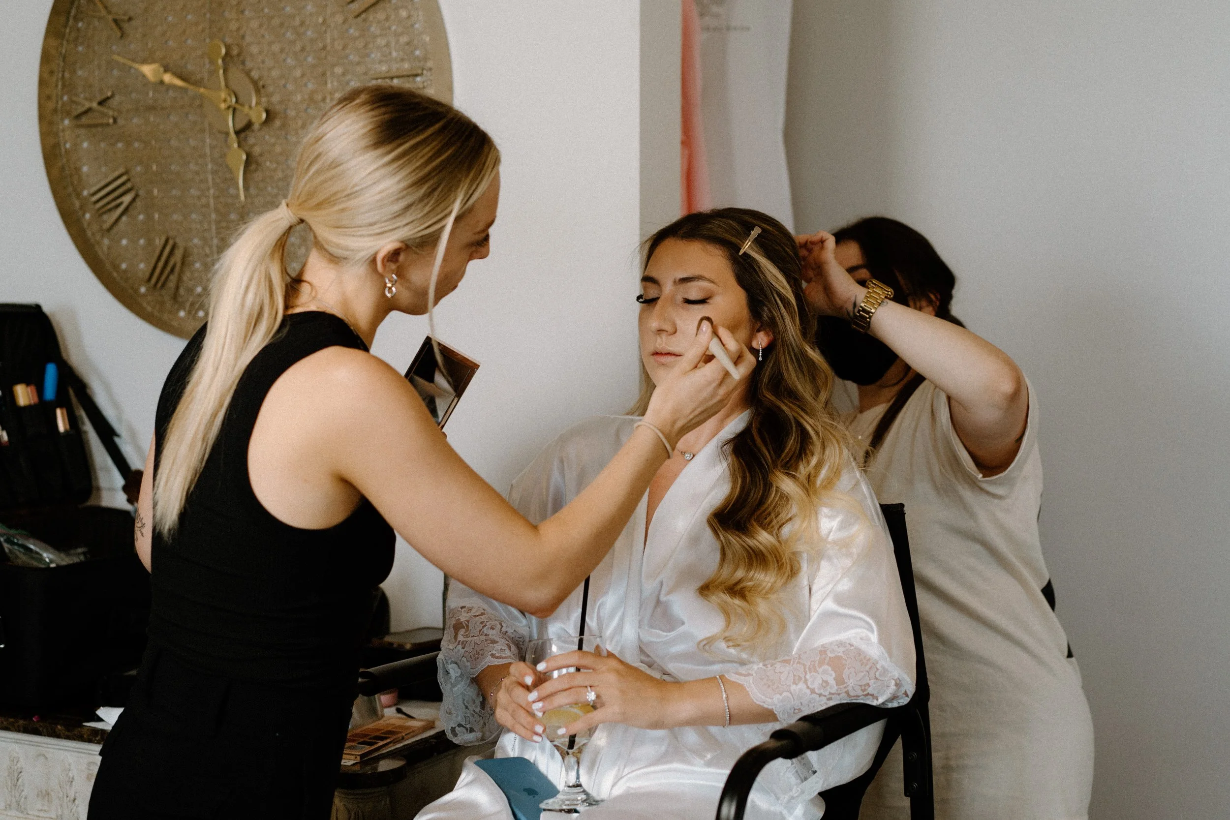 Bride getting makeup done on wedding day at The Manor House