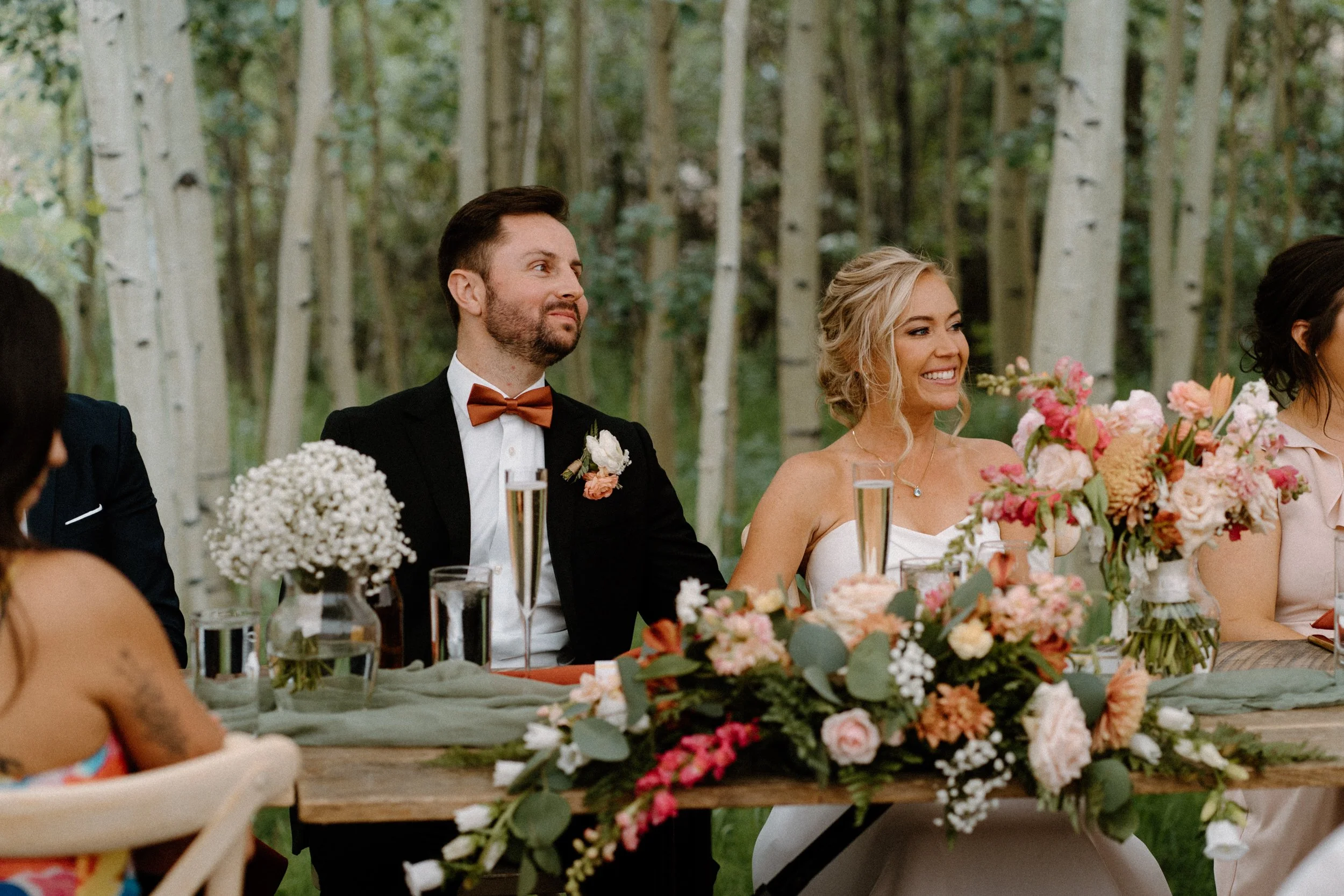 Bride and groom smiling during speeches on wedding day at Blackstone Rivers Ranch