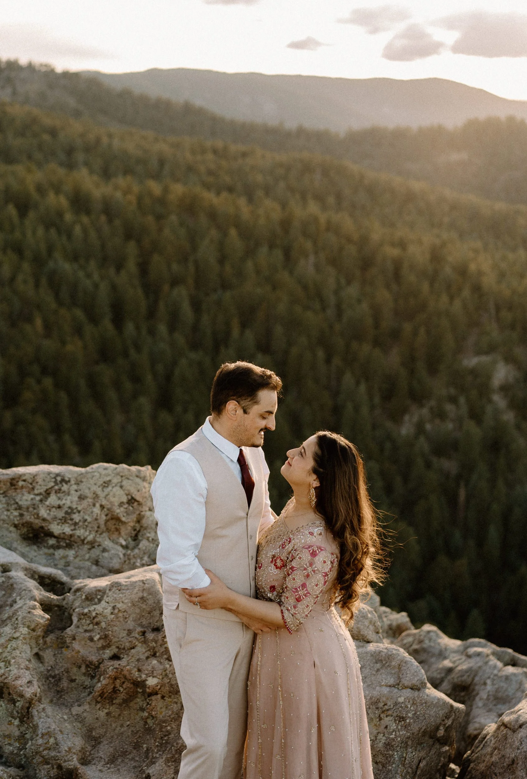 Couple smiling and holding each other during an engagement session in Boulder Colorado