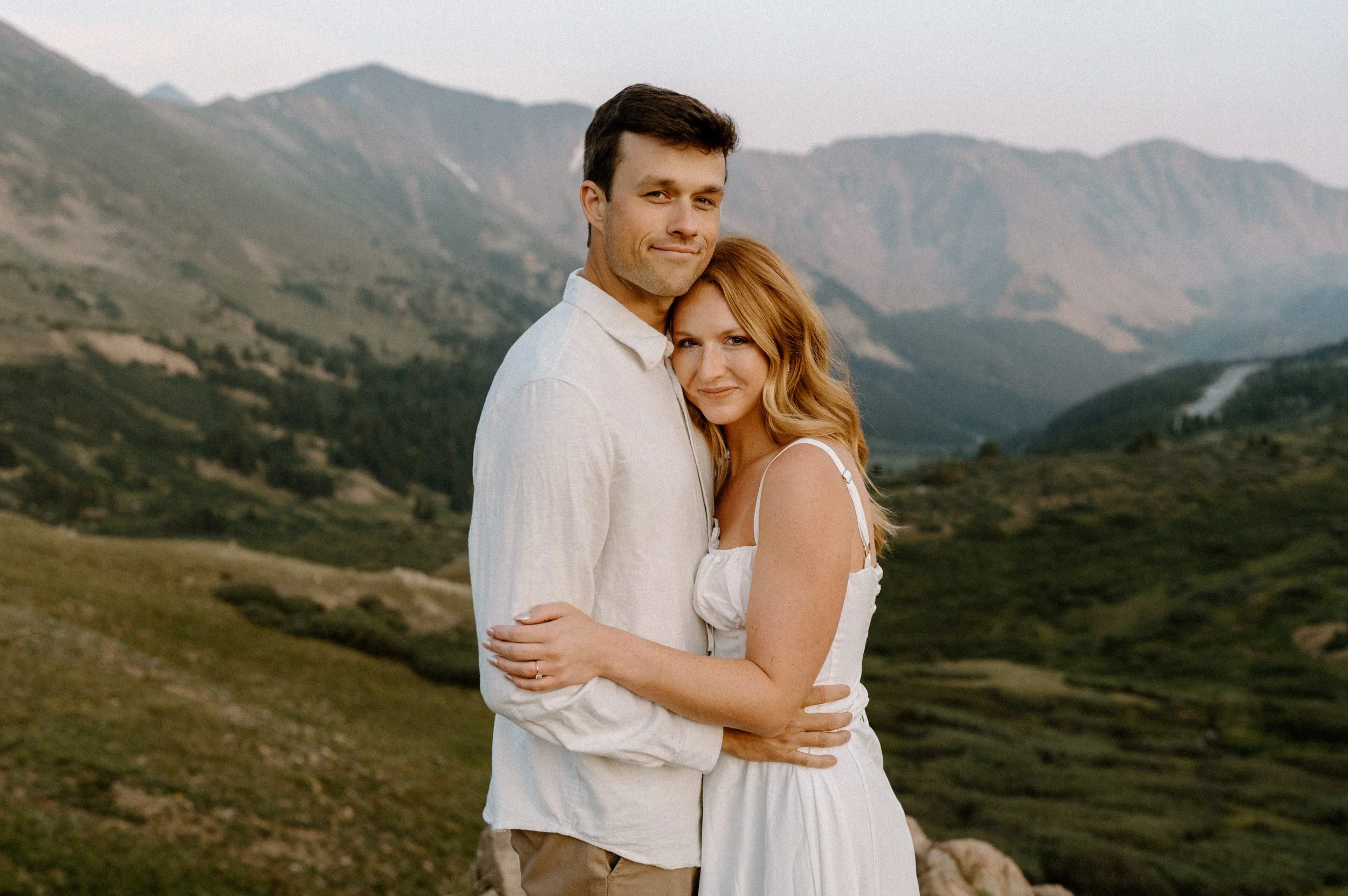 Couple smiling at the camera at Loveland Pass during engagement session