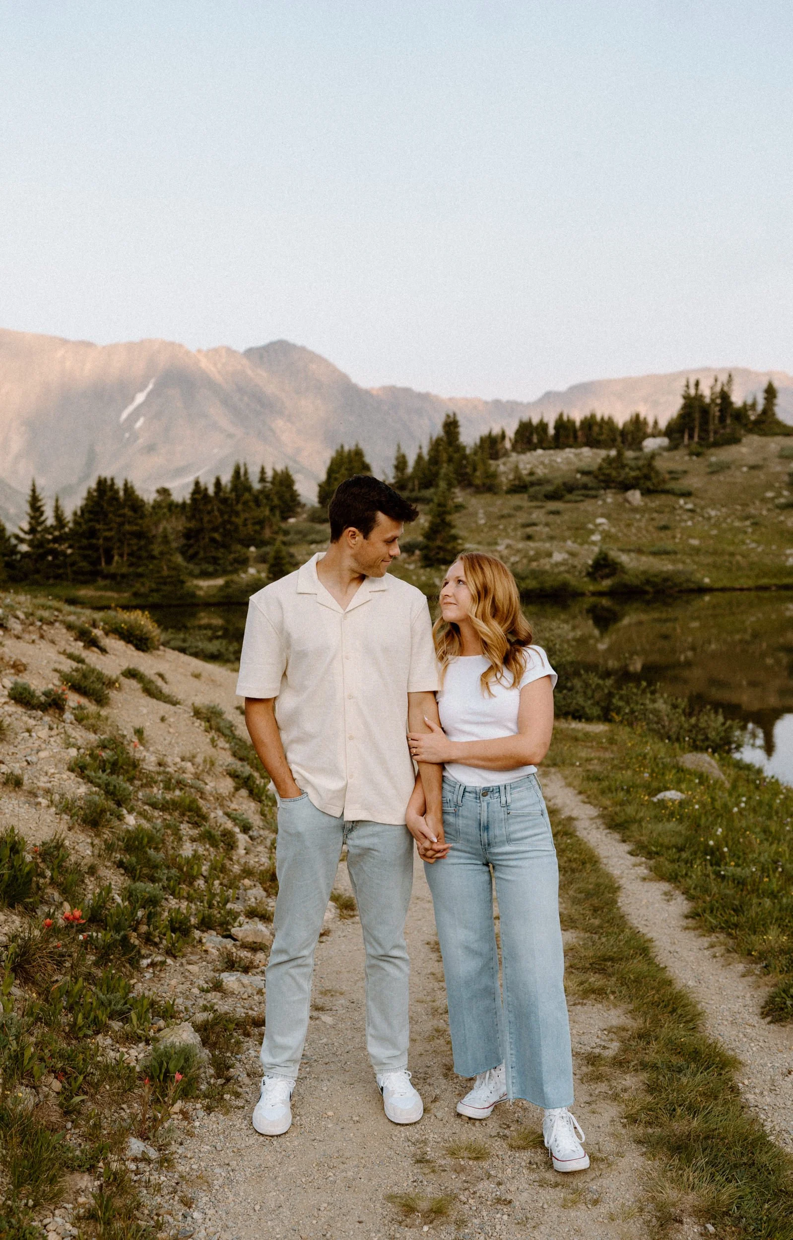 Couple looking at each other and smiling on a trail at Loveland Pass during engagement session