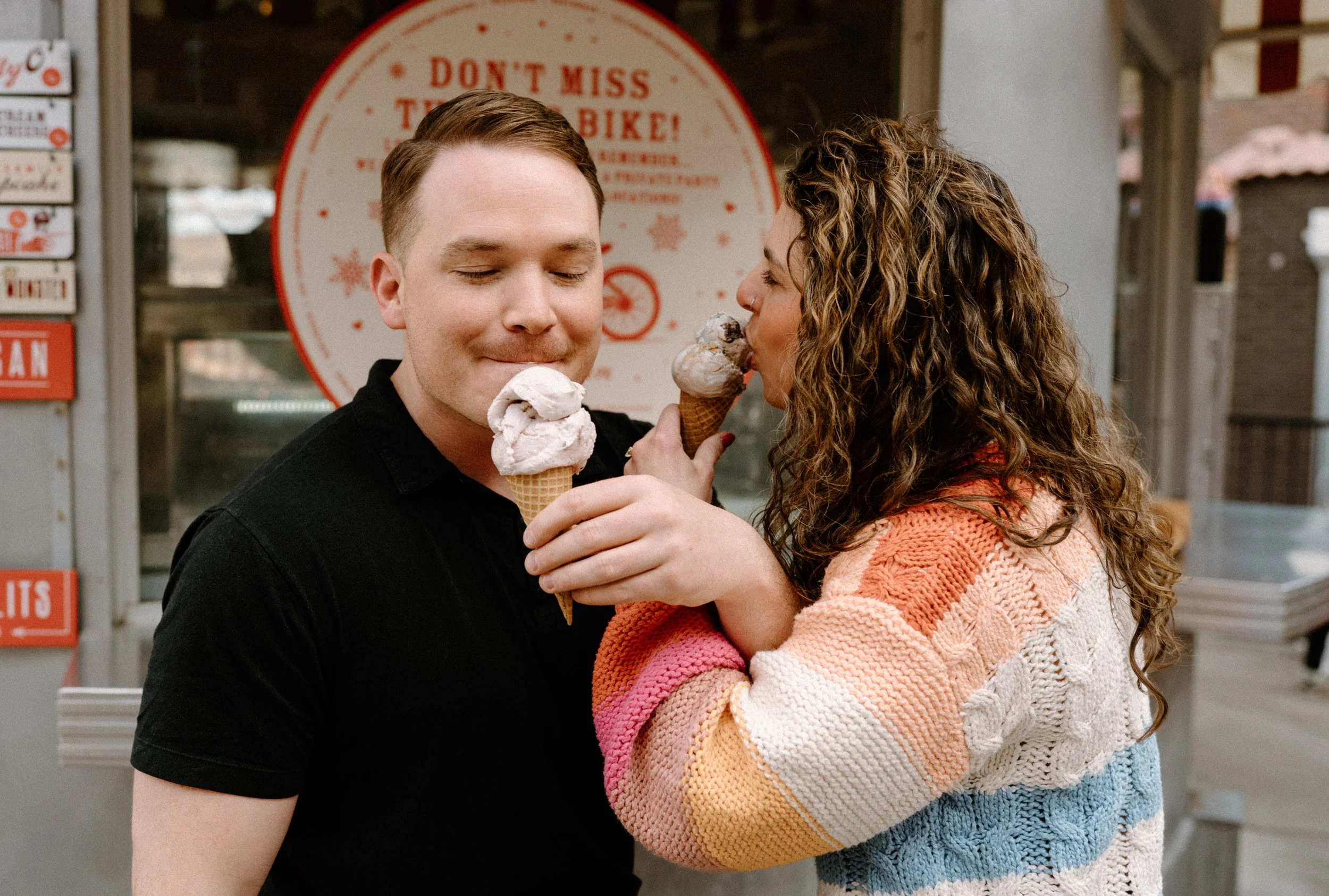 Couple feeding each other ice cream out Little Man during an engagement session