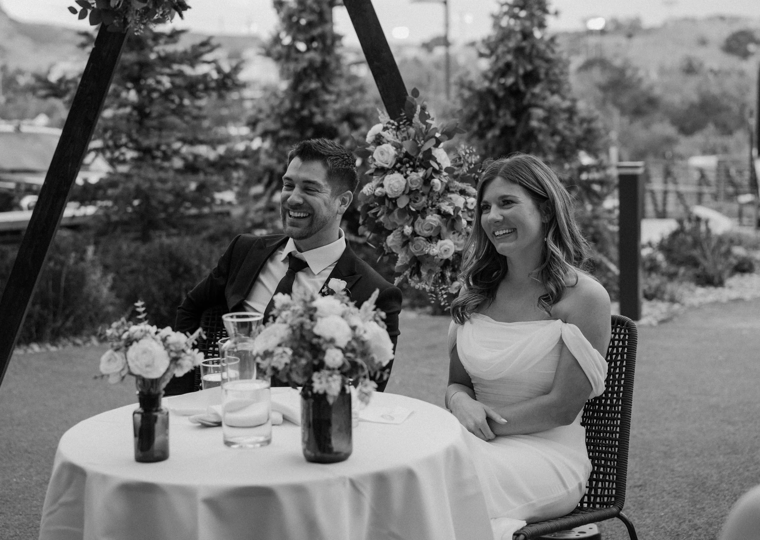 Bride and groom smiling during speeches on wedding day at The Eddy in Golden Colorado