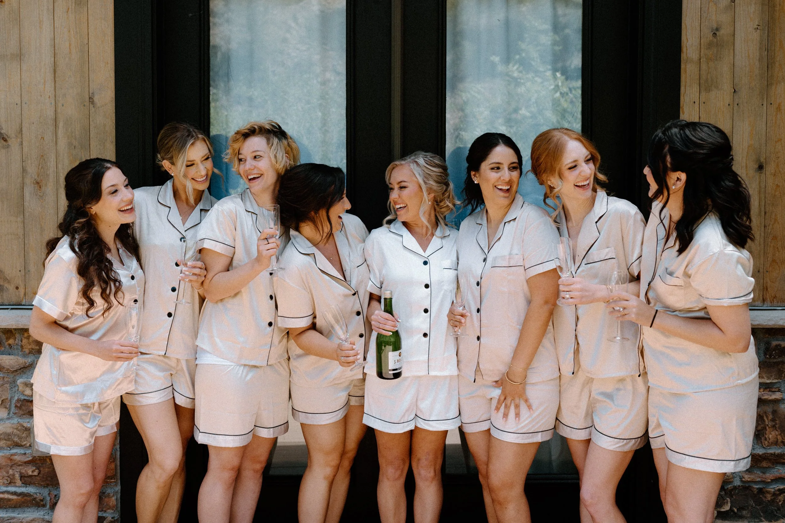Bride and bridesmaids laughing on wedding day at Blackstone Rivers Ranch