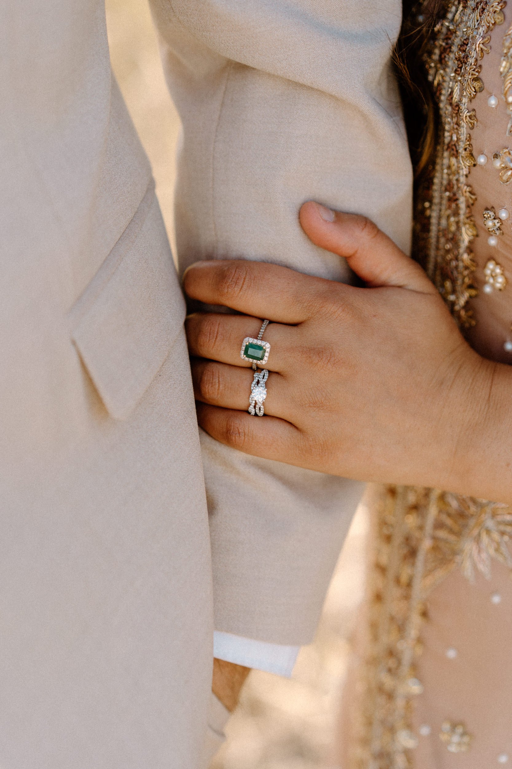 Fiancée holding fiancé's arm showing engagement ring during an engagement session in Boulder Colorado