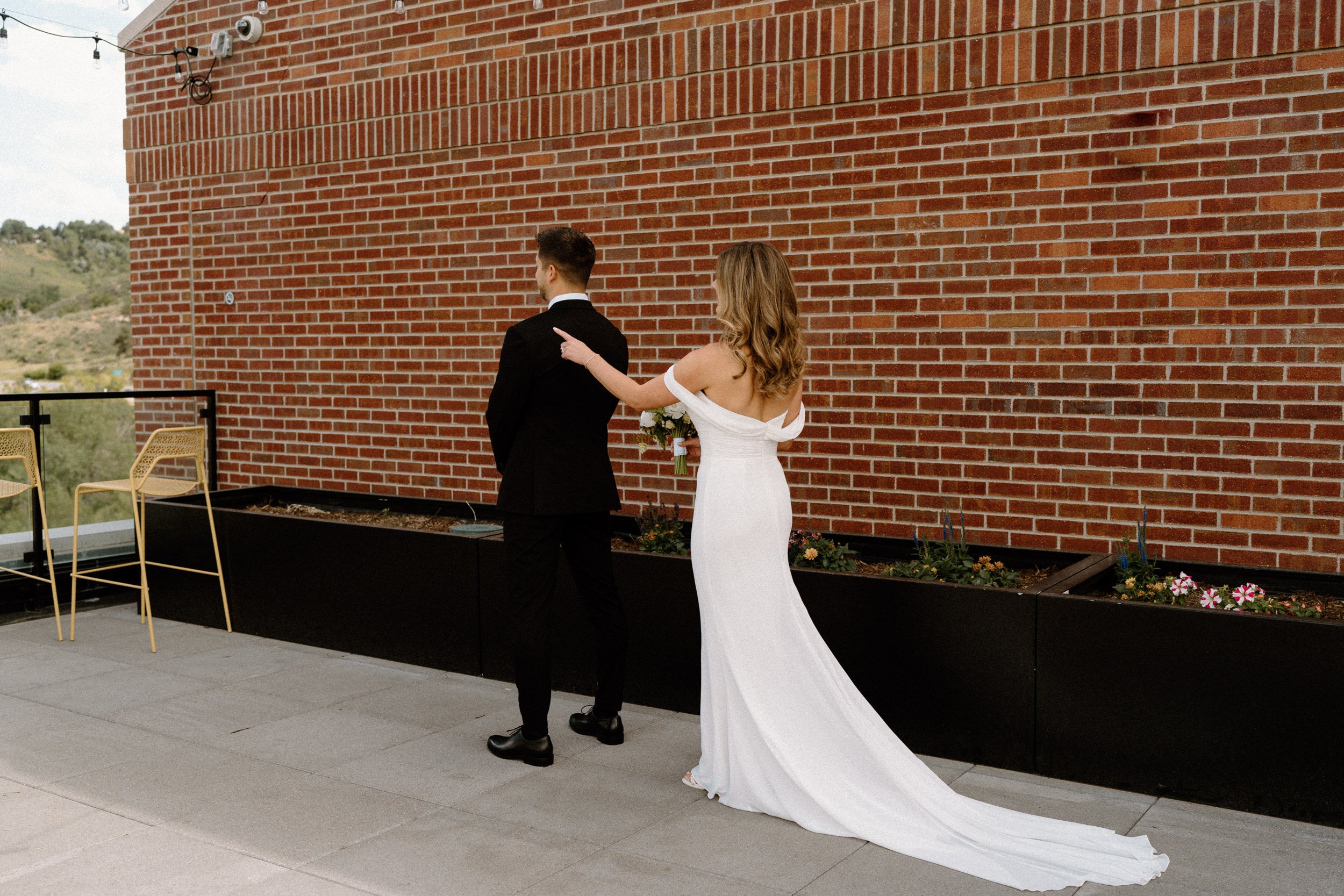 Bride tapping on grooms shoulder for first look on wedding day at The Eddy in Golden Colorado