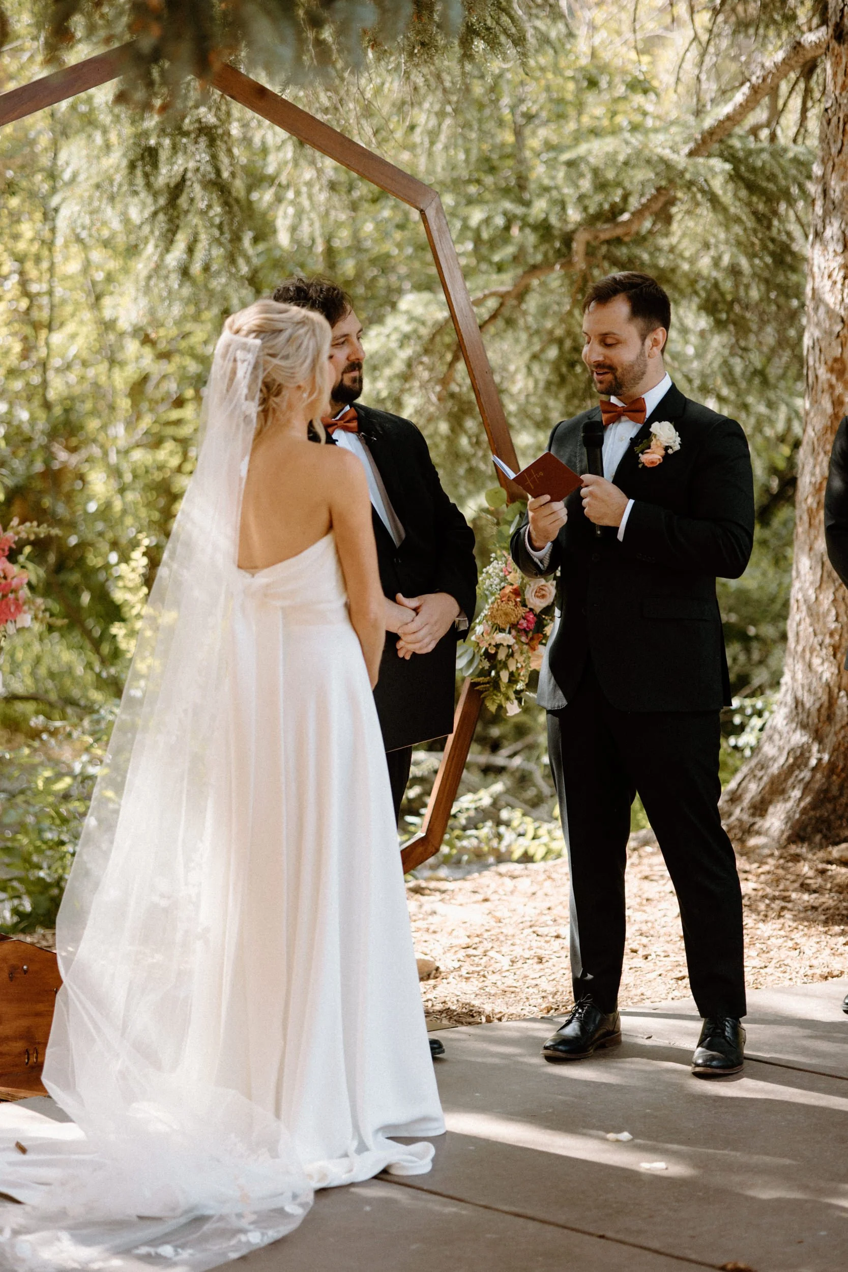 Groom reading vows to bride during ceremony on wedding day at Blackstone Rivers Ranch