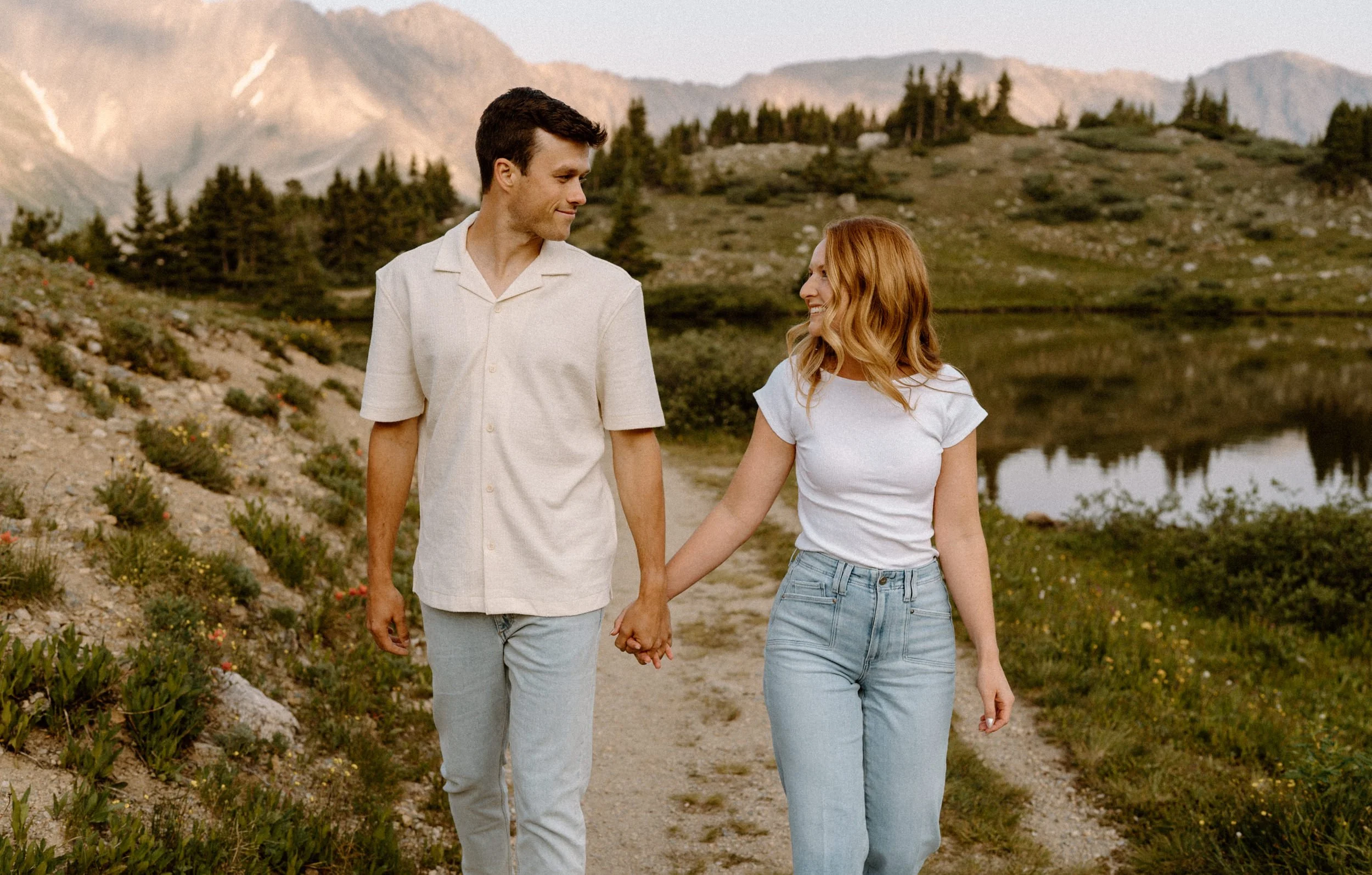 Couple smiling at each other while hiking at Loveland Pass during an engagement session