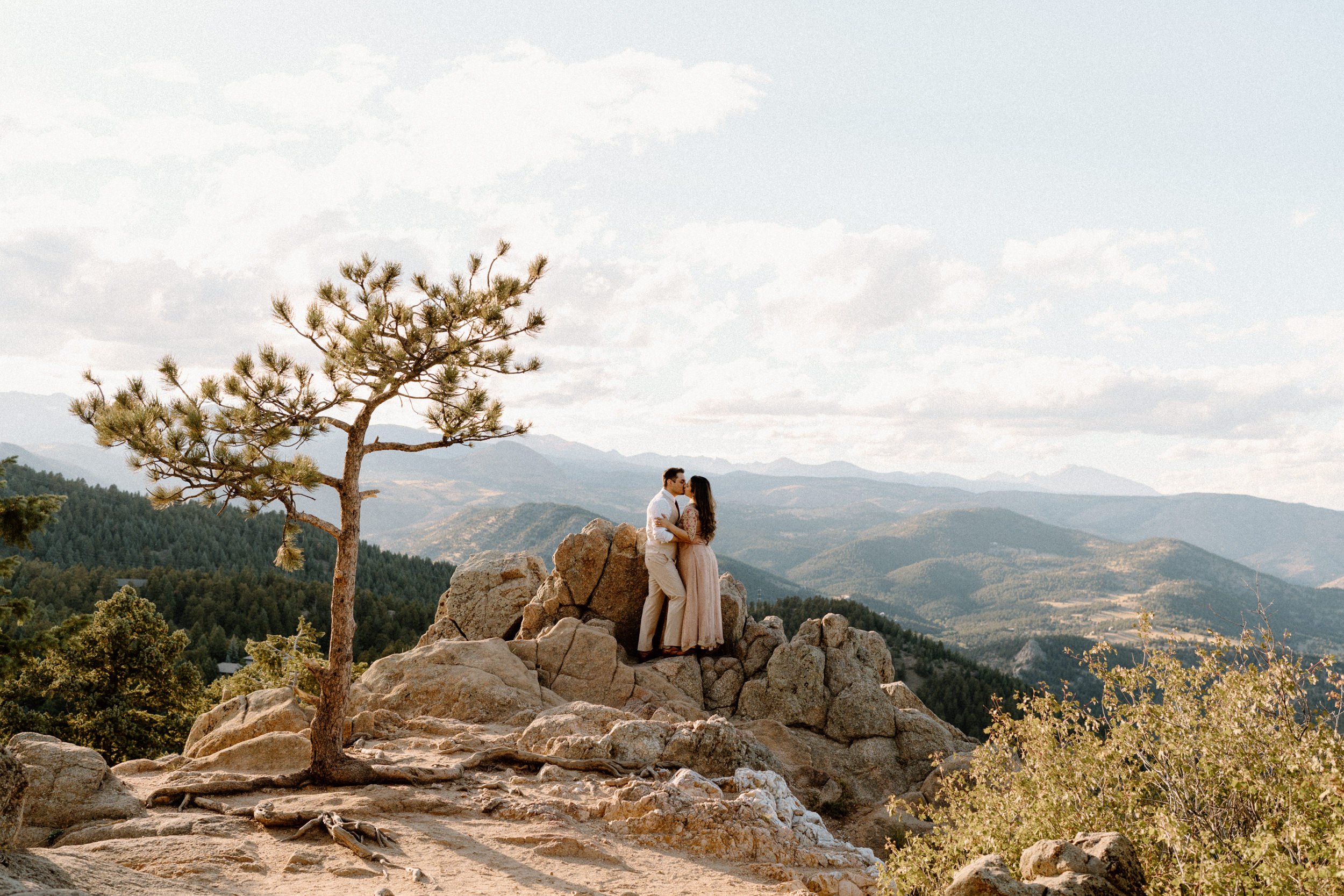 Couple kissing on top of a mountain during an engagement session in Boulder Colorado