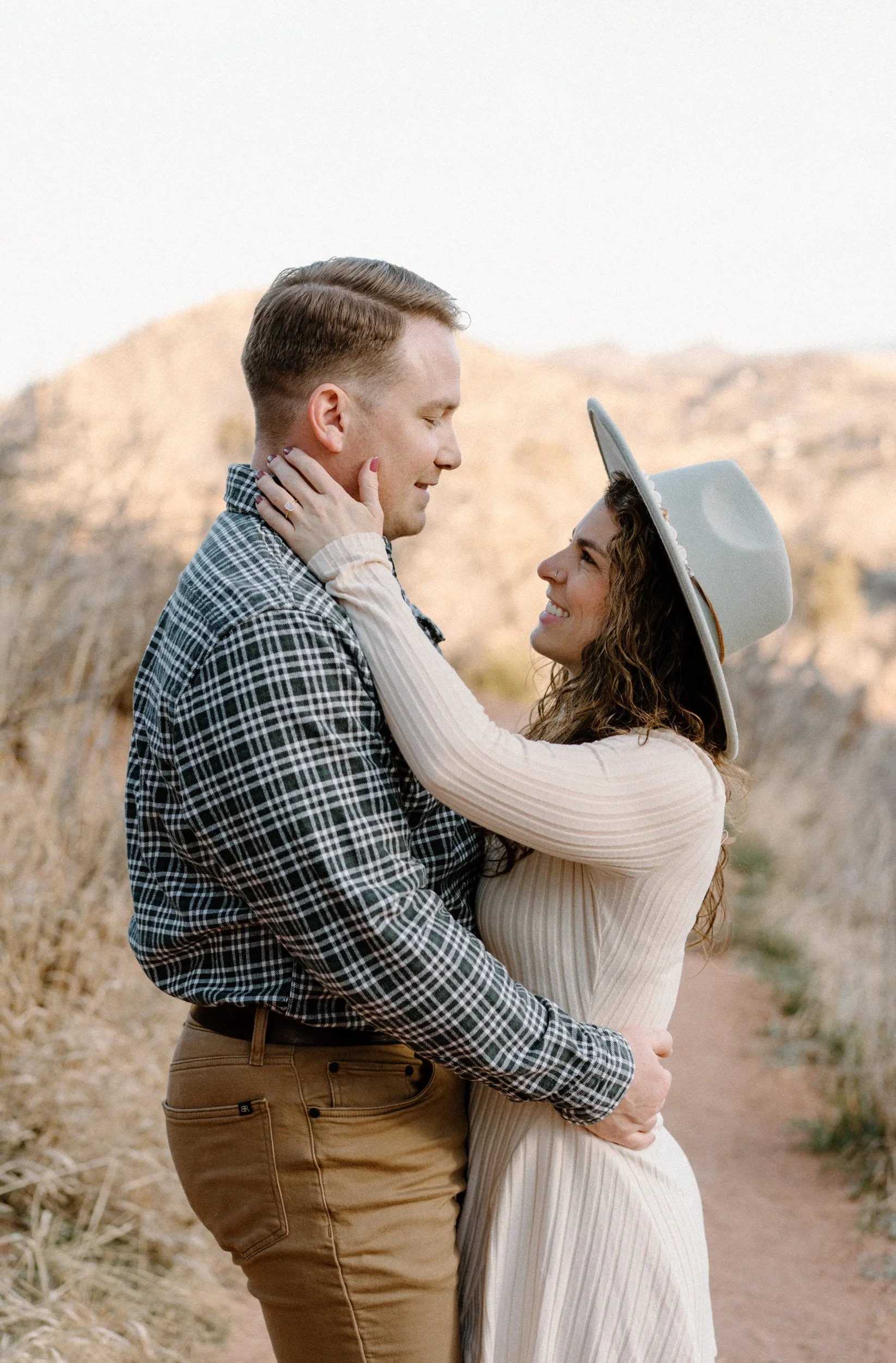 Couple smiling at each other during an engagement session in Red Rocks