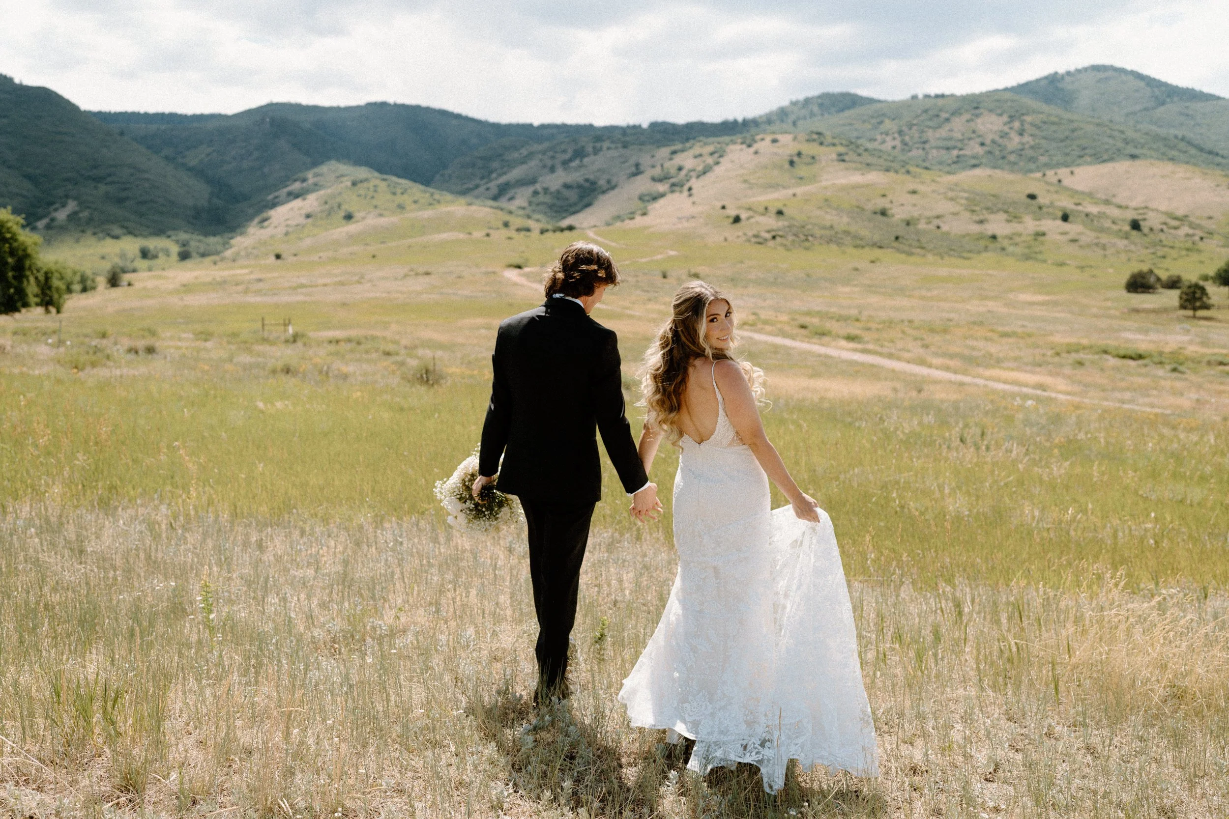 Bride and groom walking in a field during first look on wedding day at The Manor House