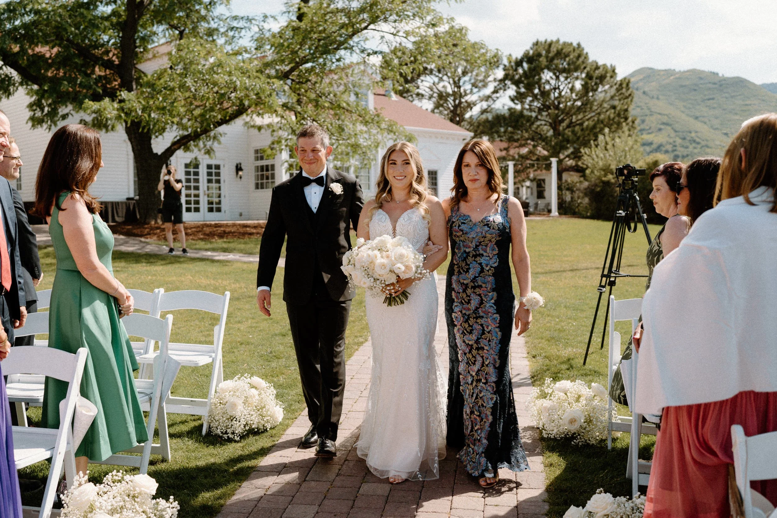 Bride and parents walking down the aisle at The Manor House on wedding day