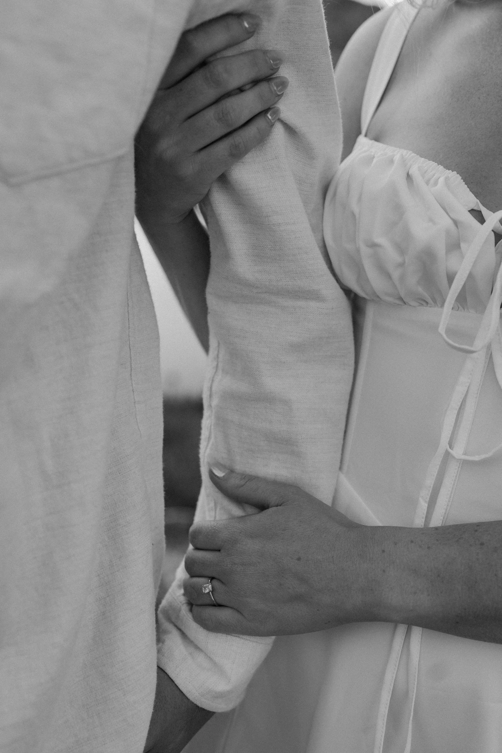 Fiancé holding fiancées arm showing engagement ring during an engagement photoshoot at Loveland Pass