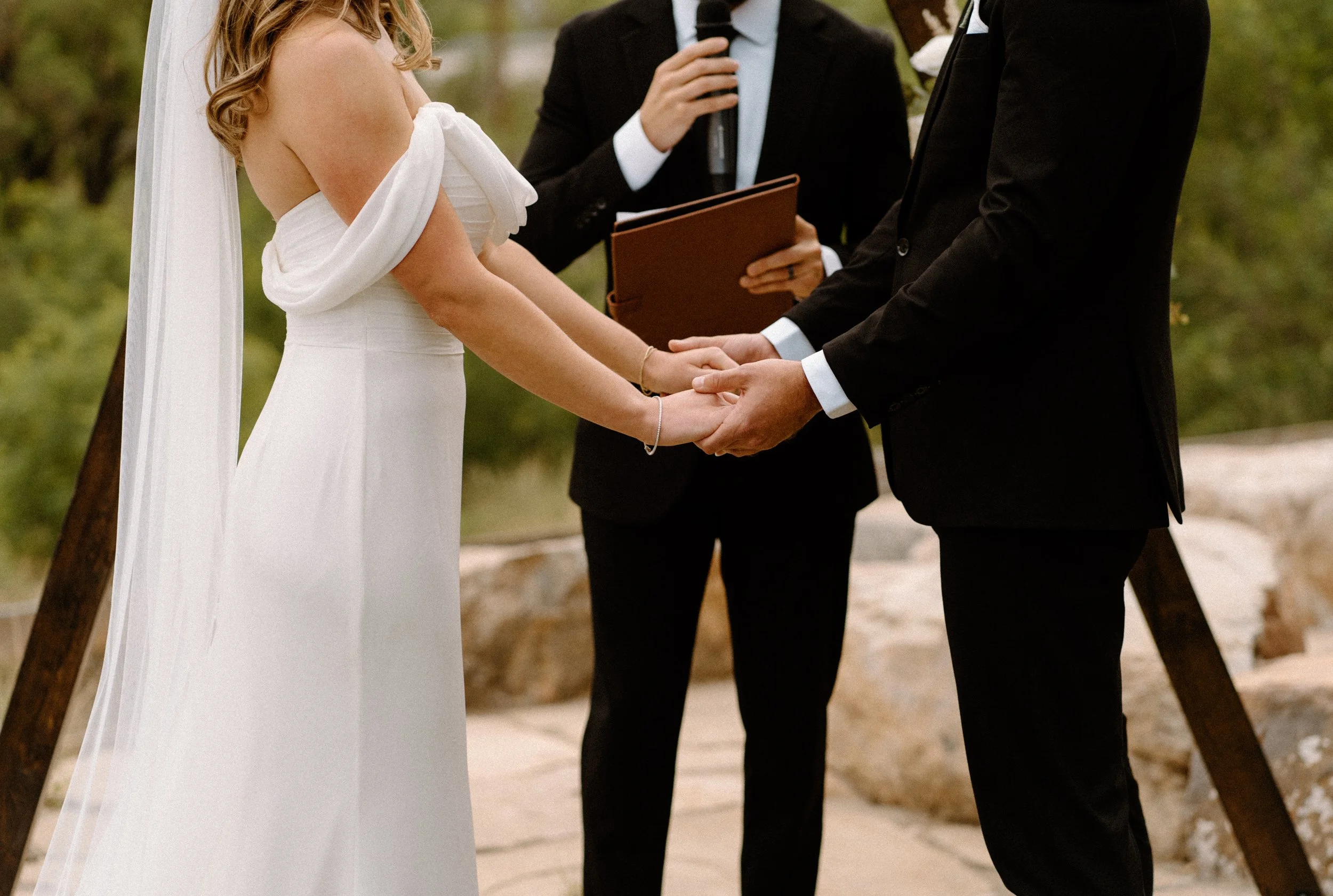 Bride and groom's hands during their ceremony on wedding day at The Eddy in Golden Colorado
