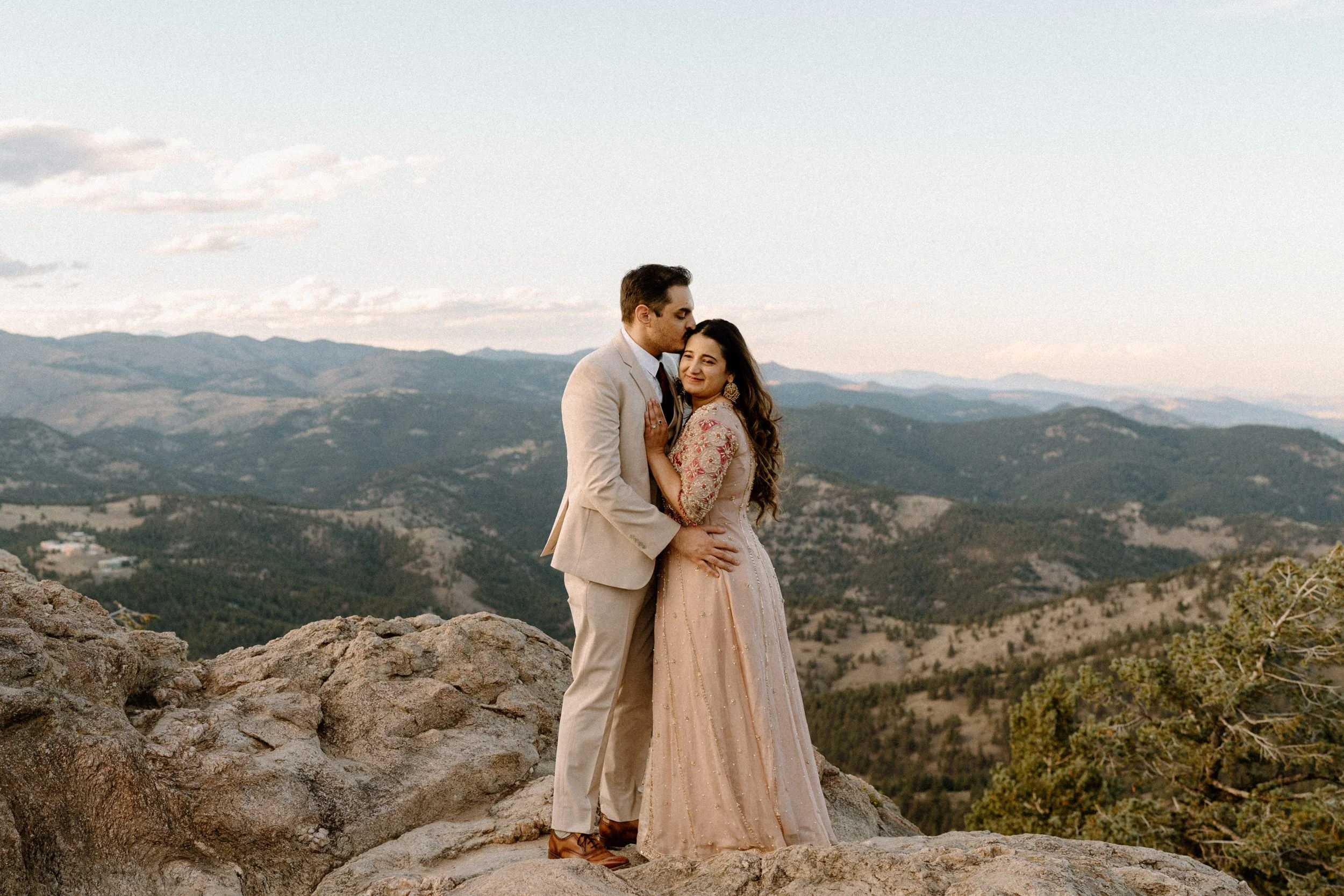 Couple hugging on top of a mountain during an engagement shoot in Boulder Colorado