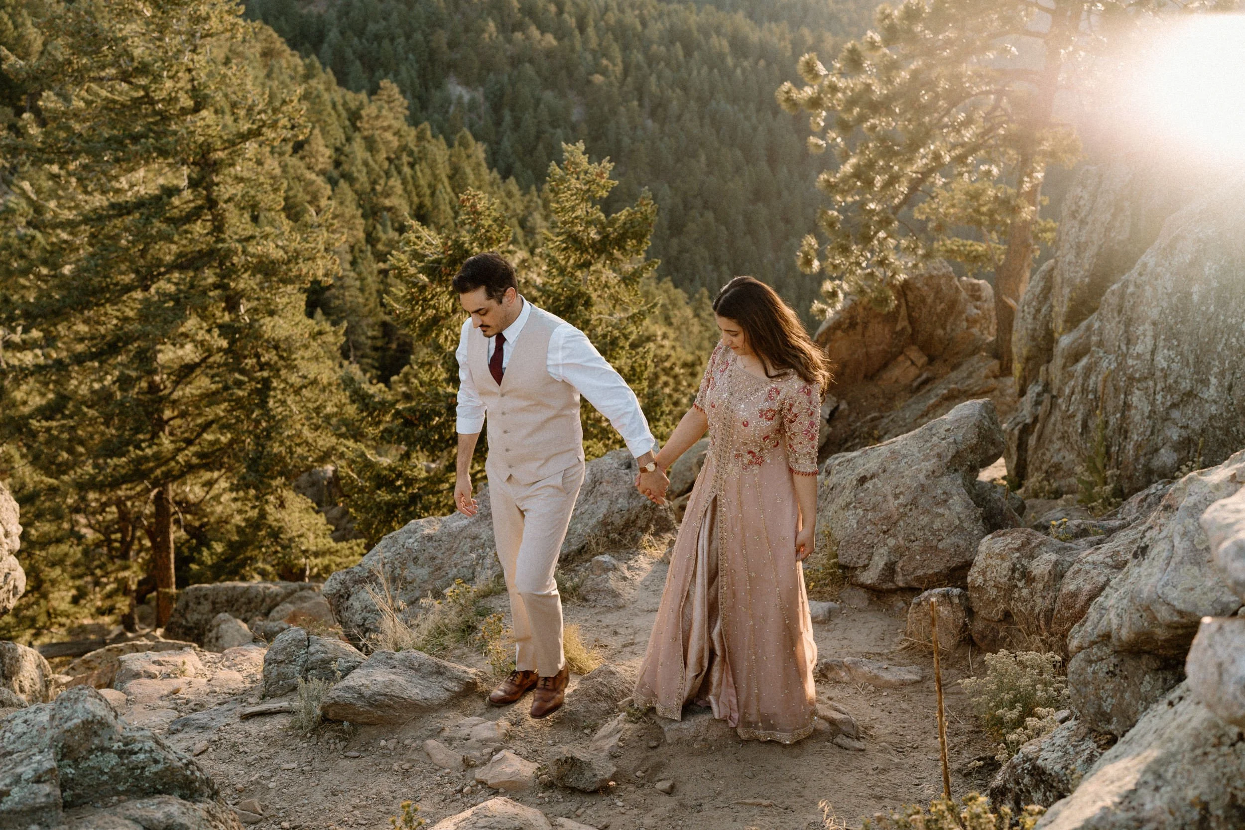 Couple holding hands and walking on a mountain during an engagement session in Boulder Colorado