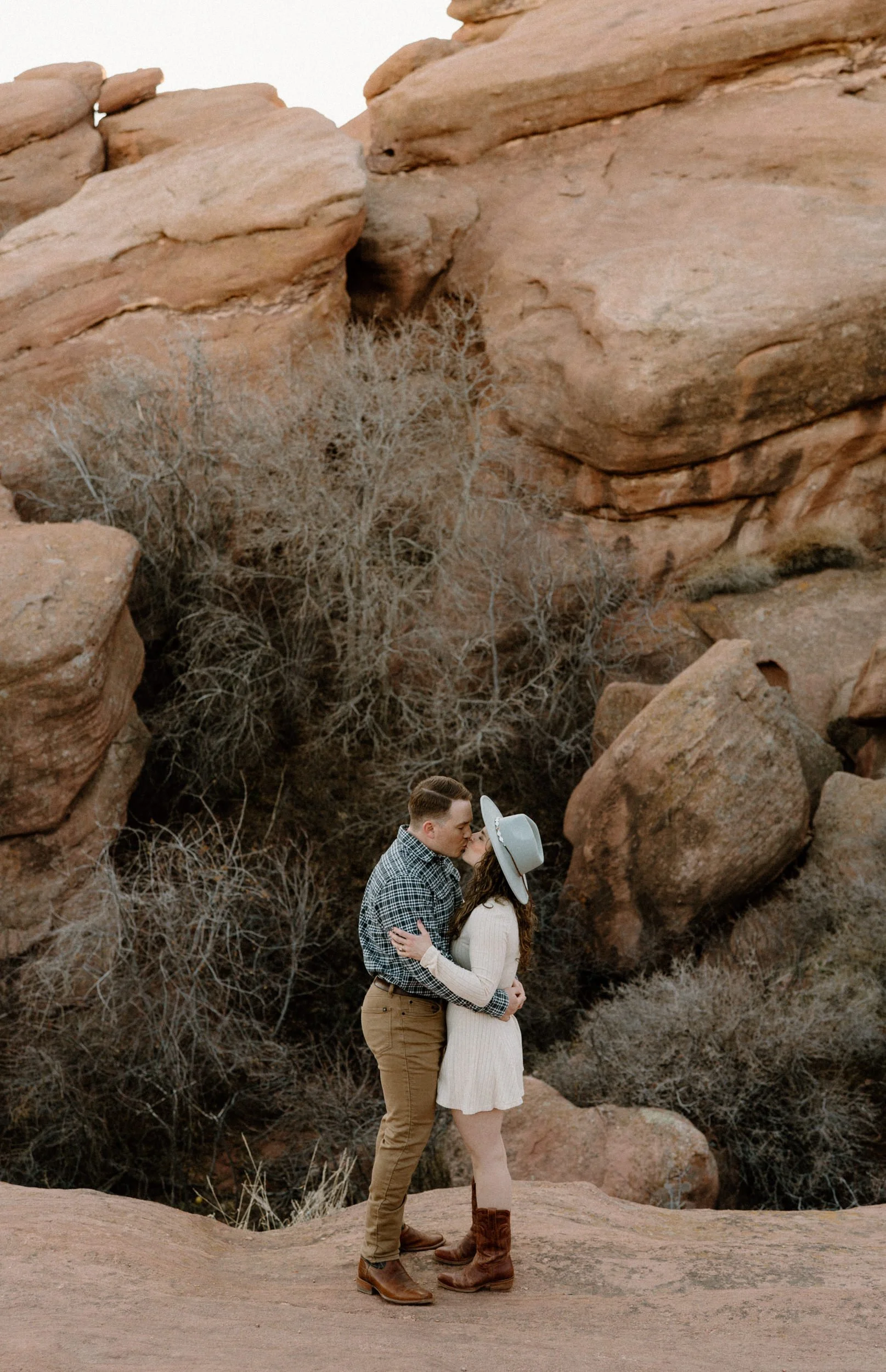 Couple kissing in Red Rocks during engagement session