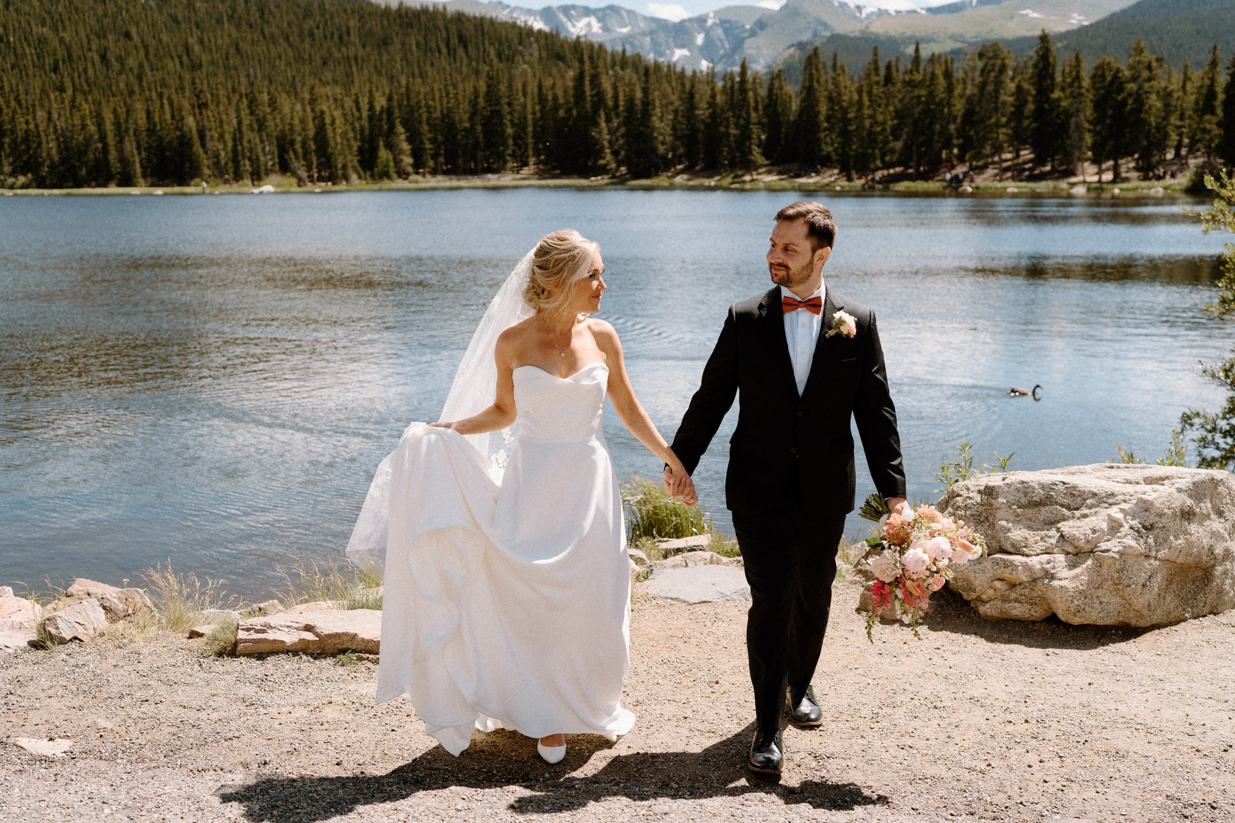 Bride and groom walking by a lake on wedding day at Blackstone Rivers Ranch